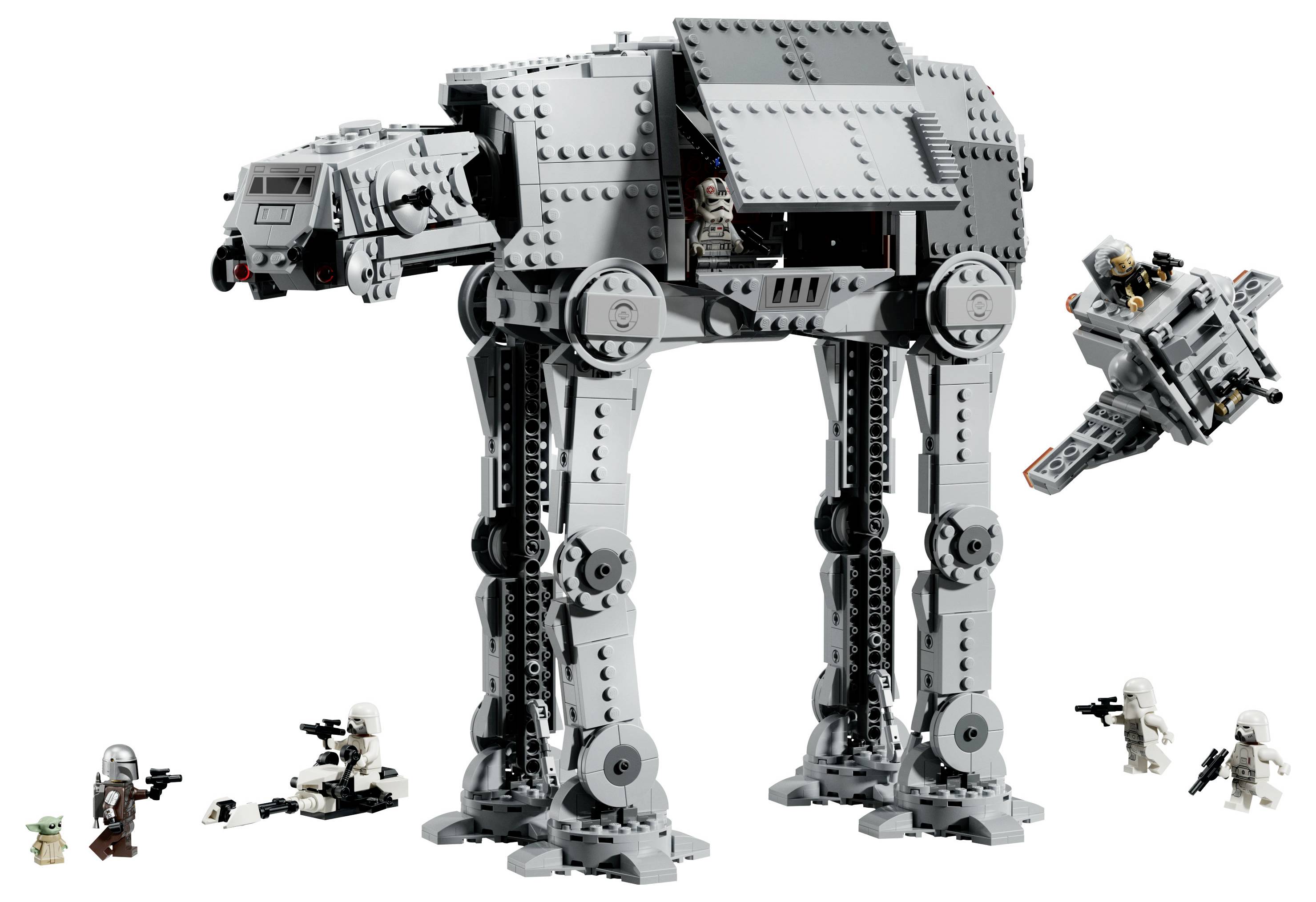 Velký šedý LEGO model AT-AT chodce se figurkami a malým speederem/lodí vystavenými kolem něj na bílém pozadí.