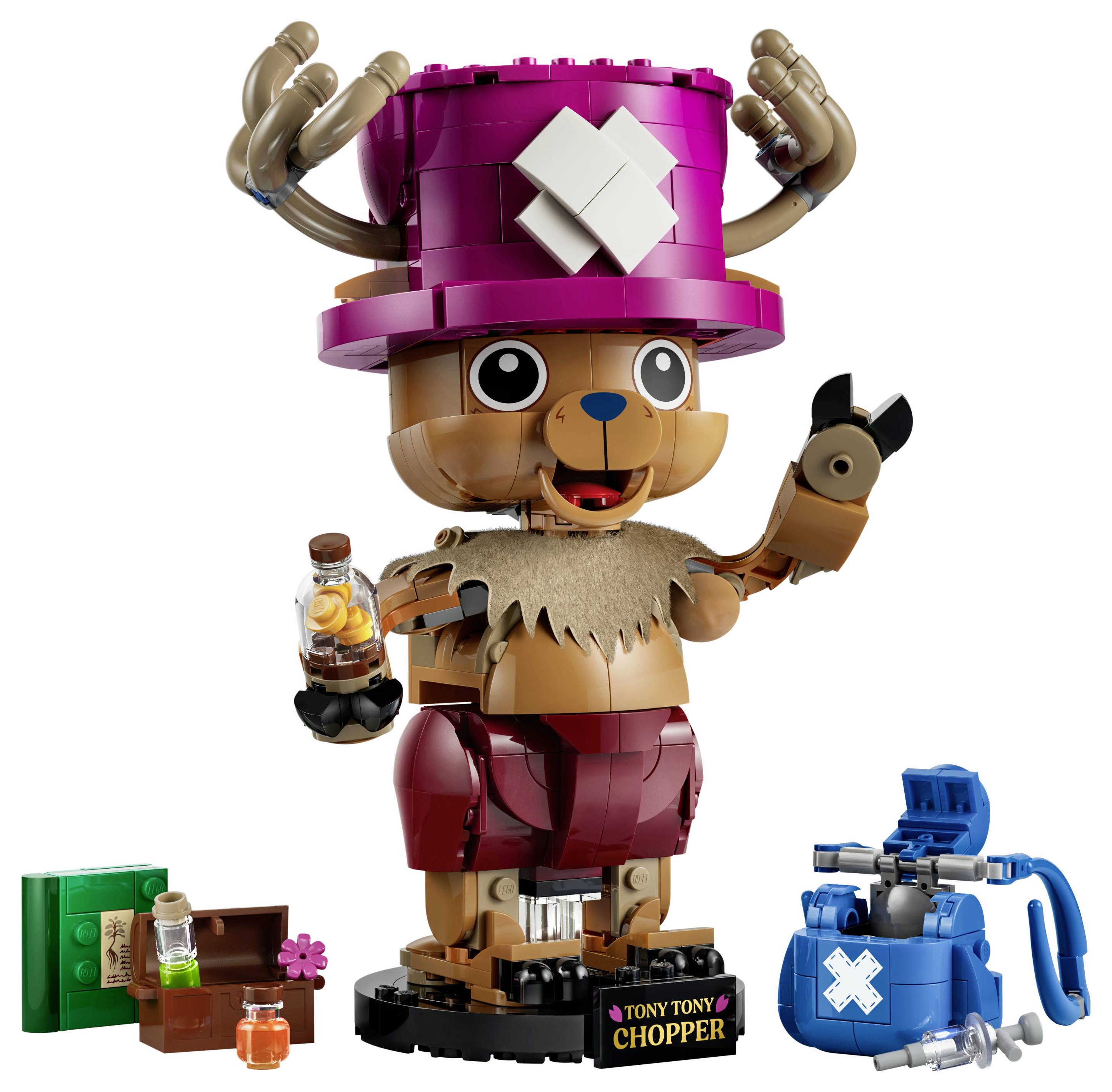 Figurka LEGO Tony Tony Chopper v jasně růžovém klobouku, držící láhev a mávající rukou, s malými stavebnicovými příslušenstvím na základně na bílém pozadí.
