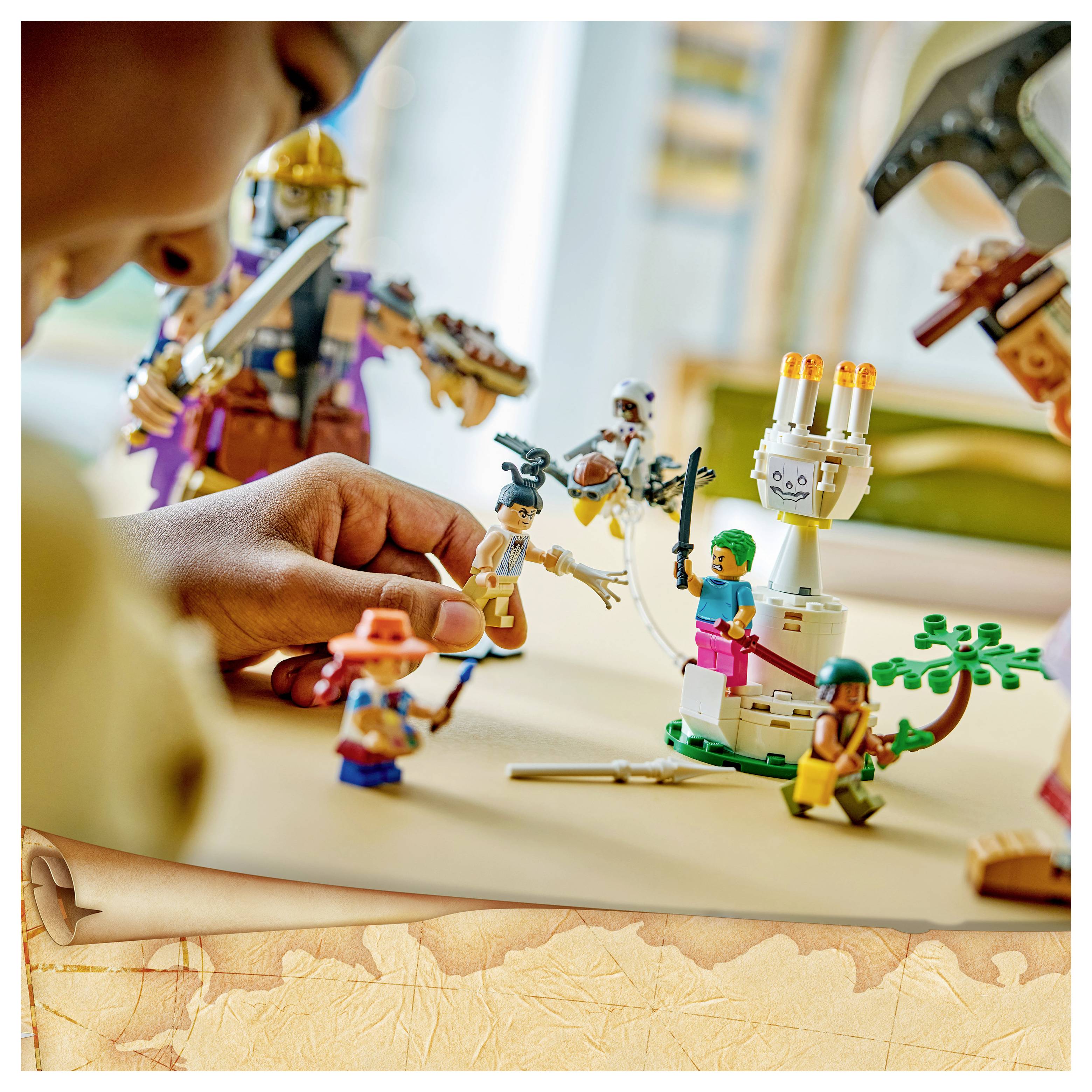 Dítě si hraje s LEGO figurkami fantasy na stolní ploše a sestavuje scénu s bílou robotickou věží a barevnými minifigurkami.