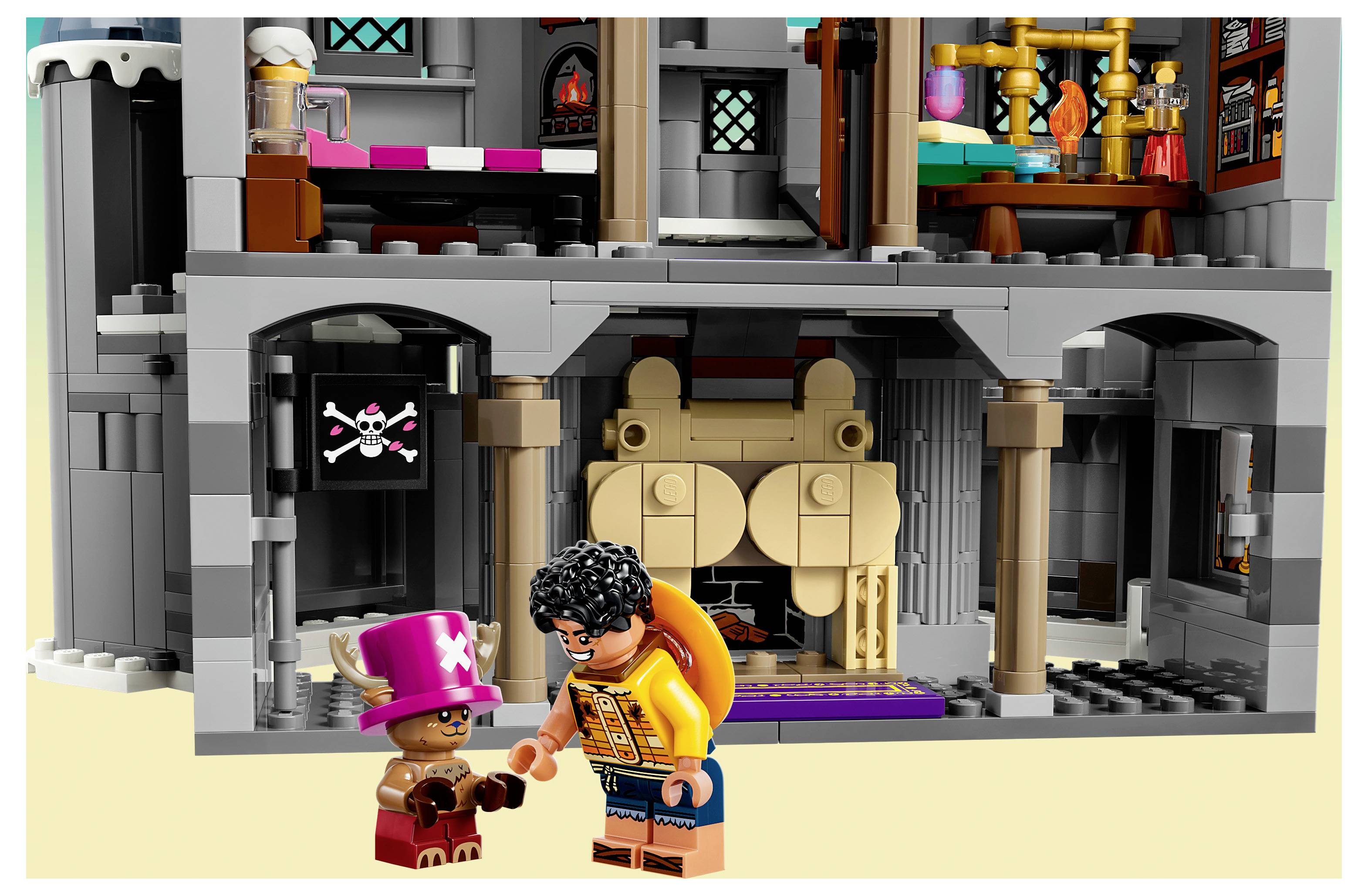 Dva LEGO figurky stojí před šedou budovou připomínající hrad, jeden v růžovém klobouku a druhý v oranžové bundě, nad vchodem je nápis s lebkou a zkříženými kostmi.