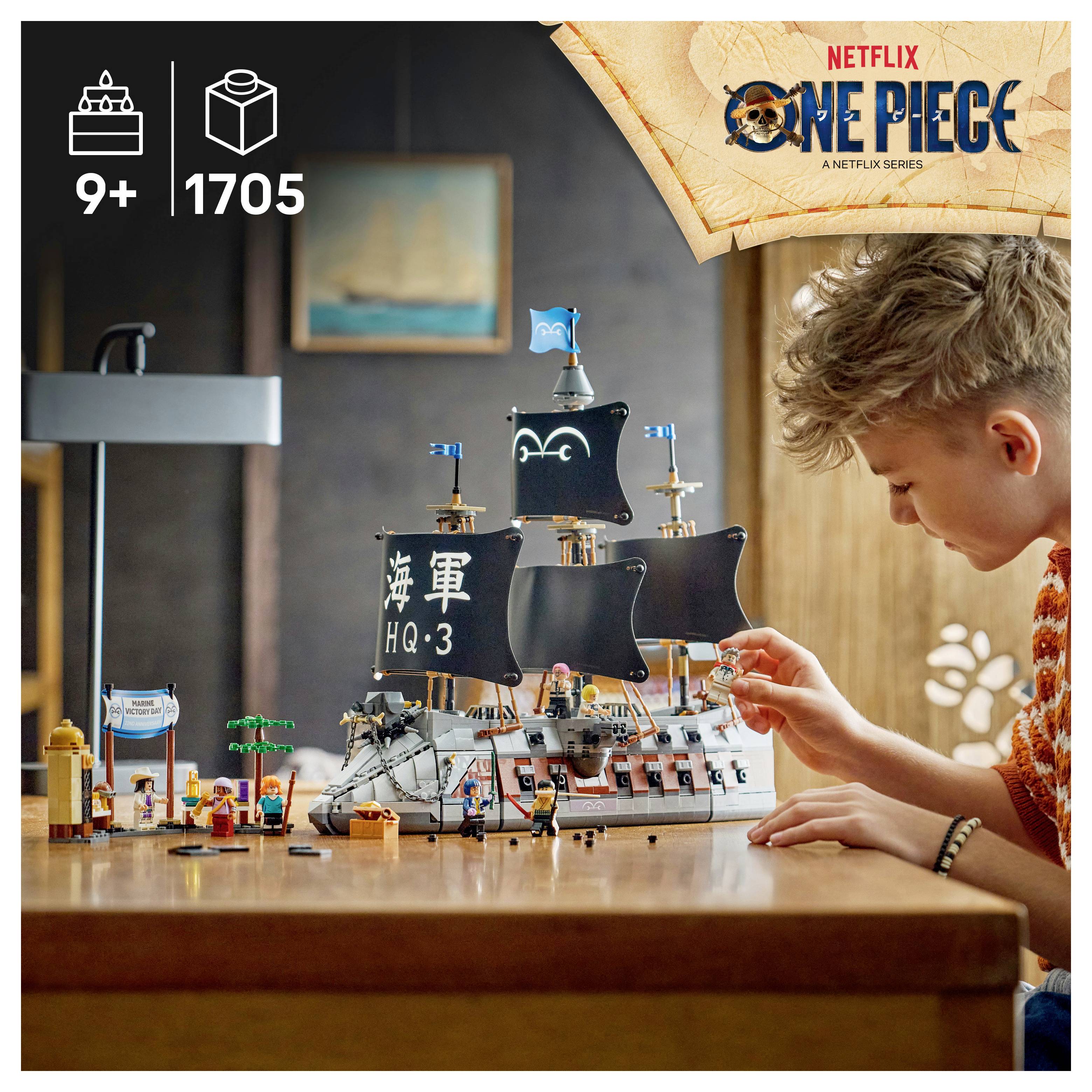 Chlapec si hraje s LEGO sadou pirátské lodi z anime One Piece na stole, se značkou „Netflix One Piece" a štítky "9+" a "1705 dílů".