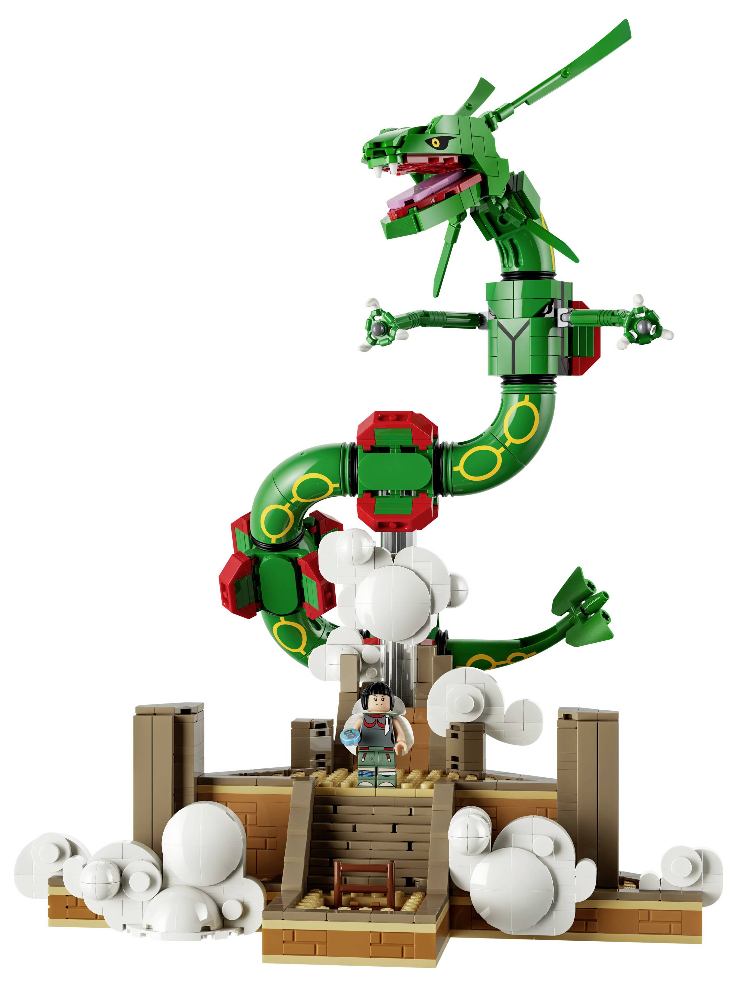 Socha draka ve stylu LEGO dominující nad malou minifigurkou na dřevěné platformě, s bílými kusy mraků na základně.