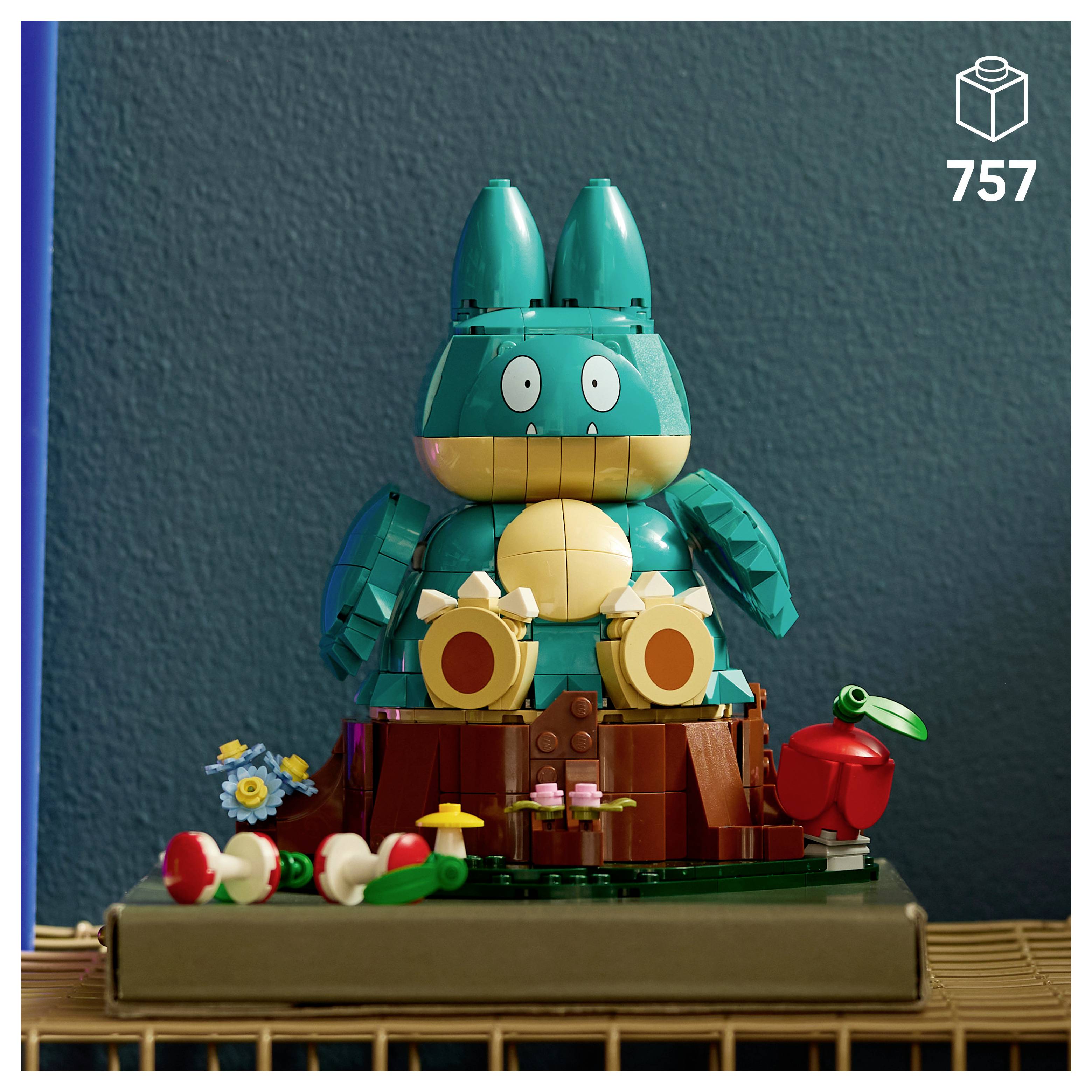 LEGO-style figurka tyrkysového králíka sedícího na základně z pařezu stromu s květinami a červeným jablkem; číslo sady 757 zobrazené v rohu.