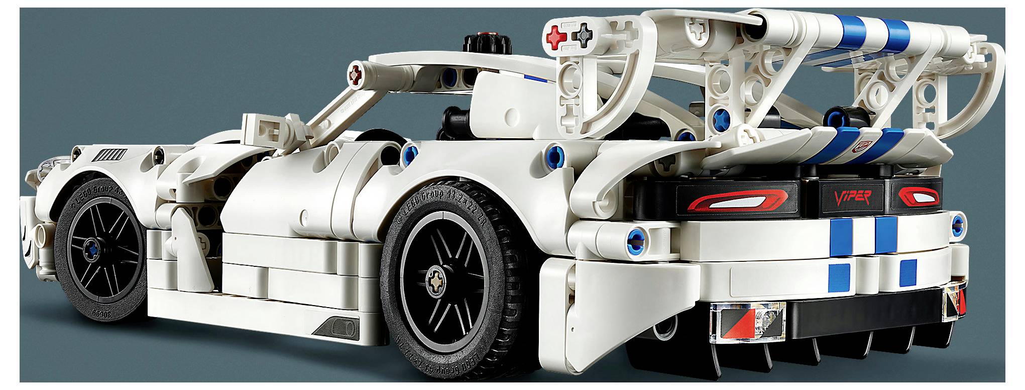 Pohled zezadu na bílý závodní vůz ve stylu LEGO s vystavěným modrým rámem, velkými koly a značením "V10" na zadních světlech.