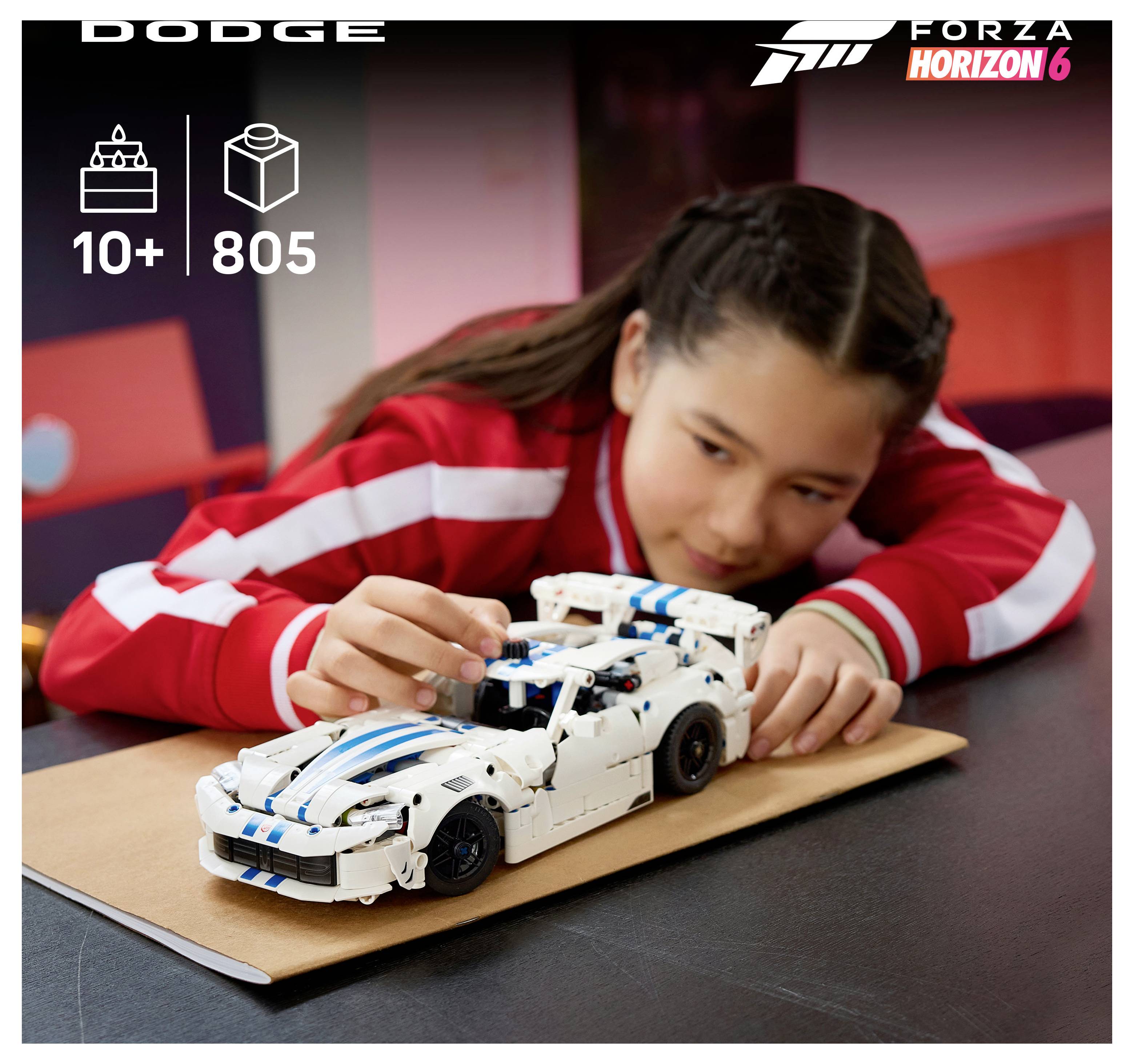Dívka v červené bundě staví na stole bílý závodní model LEGO Dodge; objevují se nápisy "DODGE", "10+", "805" a branding Forza Horizon 6.