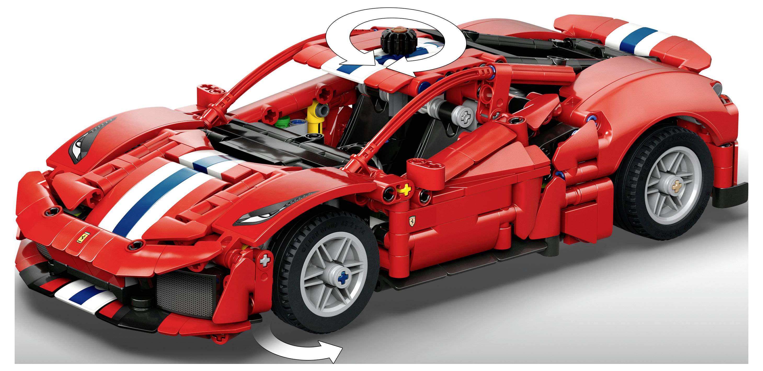 Červený model sportovního auta ve stylu LEGO v červené barvě s bílými a modrými závodními pruhy, zobrazený v řezu s otevřenými dveřmi a rotujícím střešním prvkem.