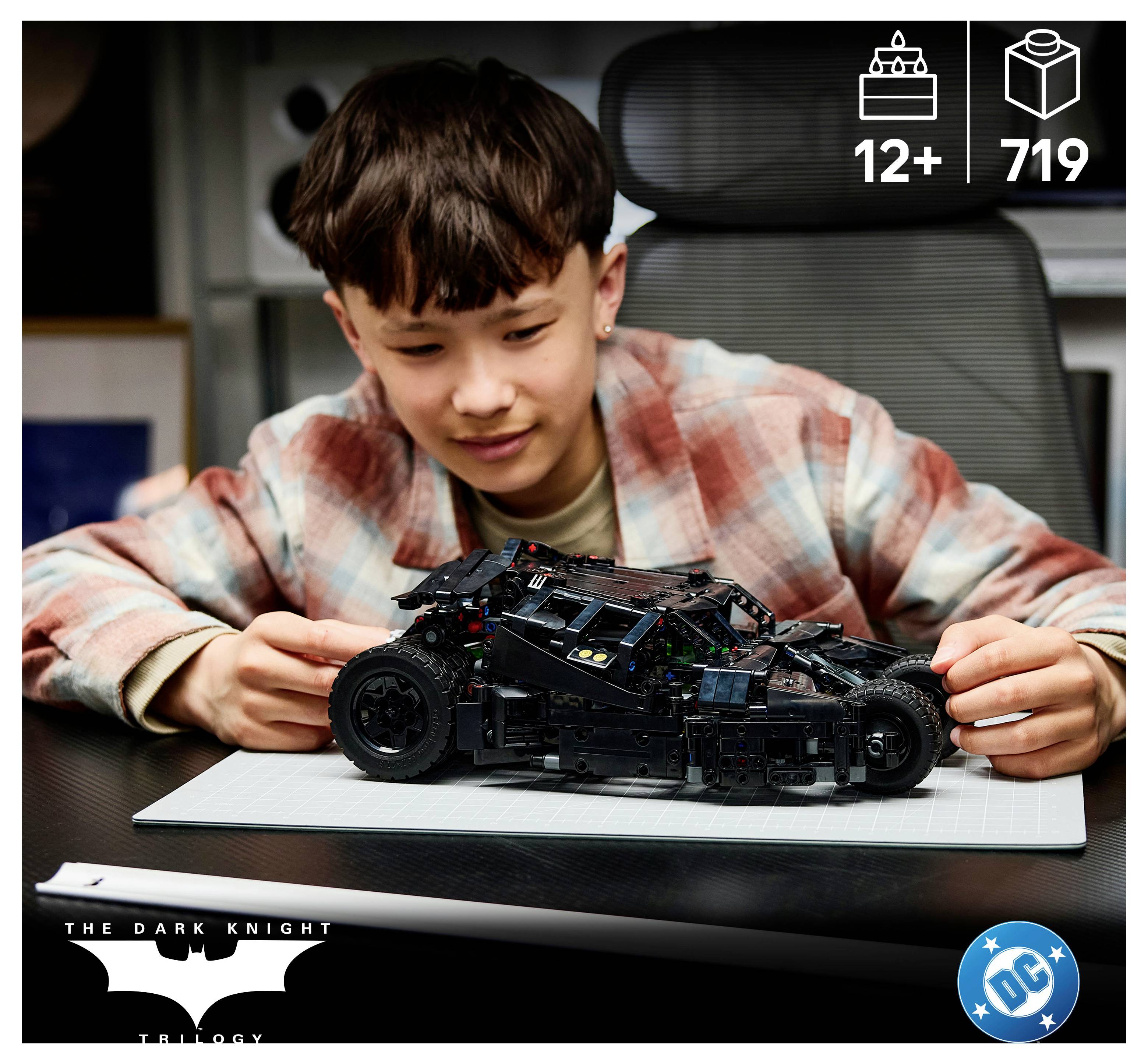 Chlapec skládá LEGO-style Batmobil ze sady "Temný rytíř - Trilogie" s označením věku 12+ a viditelnými 719 součástkami.