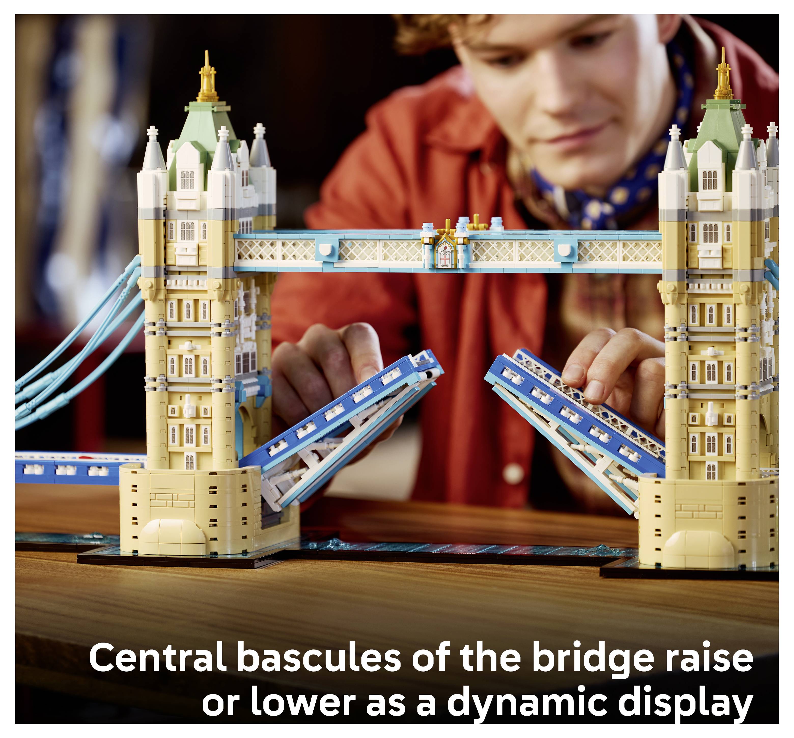 Osoba staví model LEGO Tower Bridge, přičemž střední baskuly jsou zvednuty; titulek říká "Střední baskuly mostu se zvedají nebo spouštějí jako dynamická prezentace".