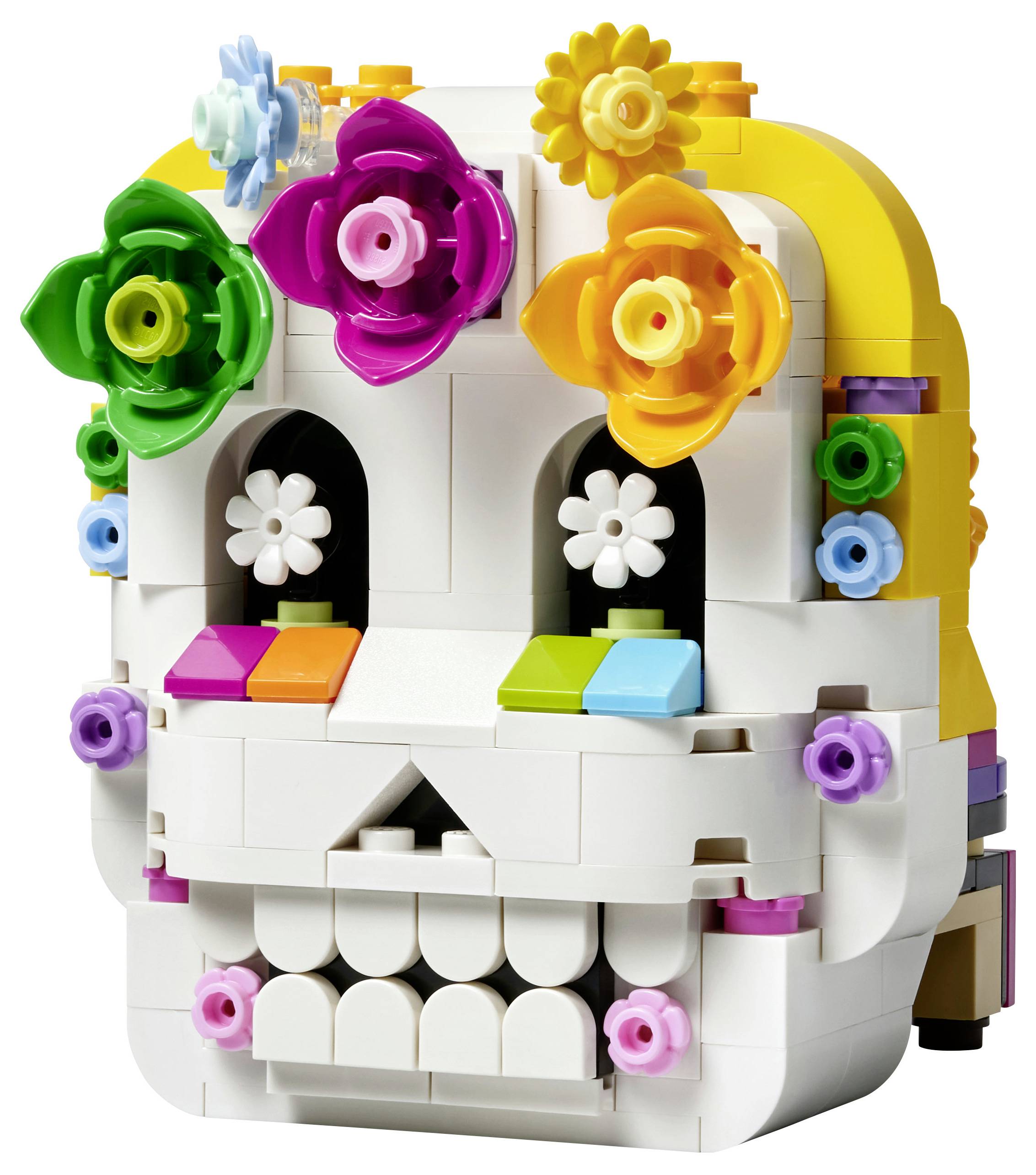 Barevná lebka ve stylu LEGO se zdobením z květin, zobrazená zepředu na bílém pozadí.