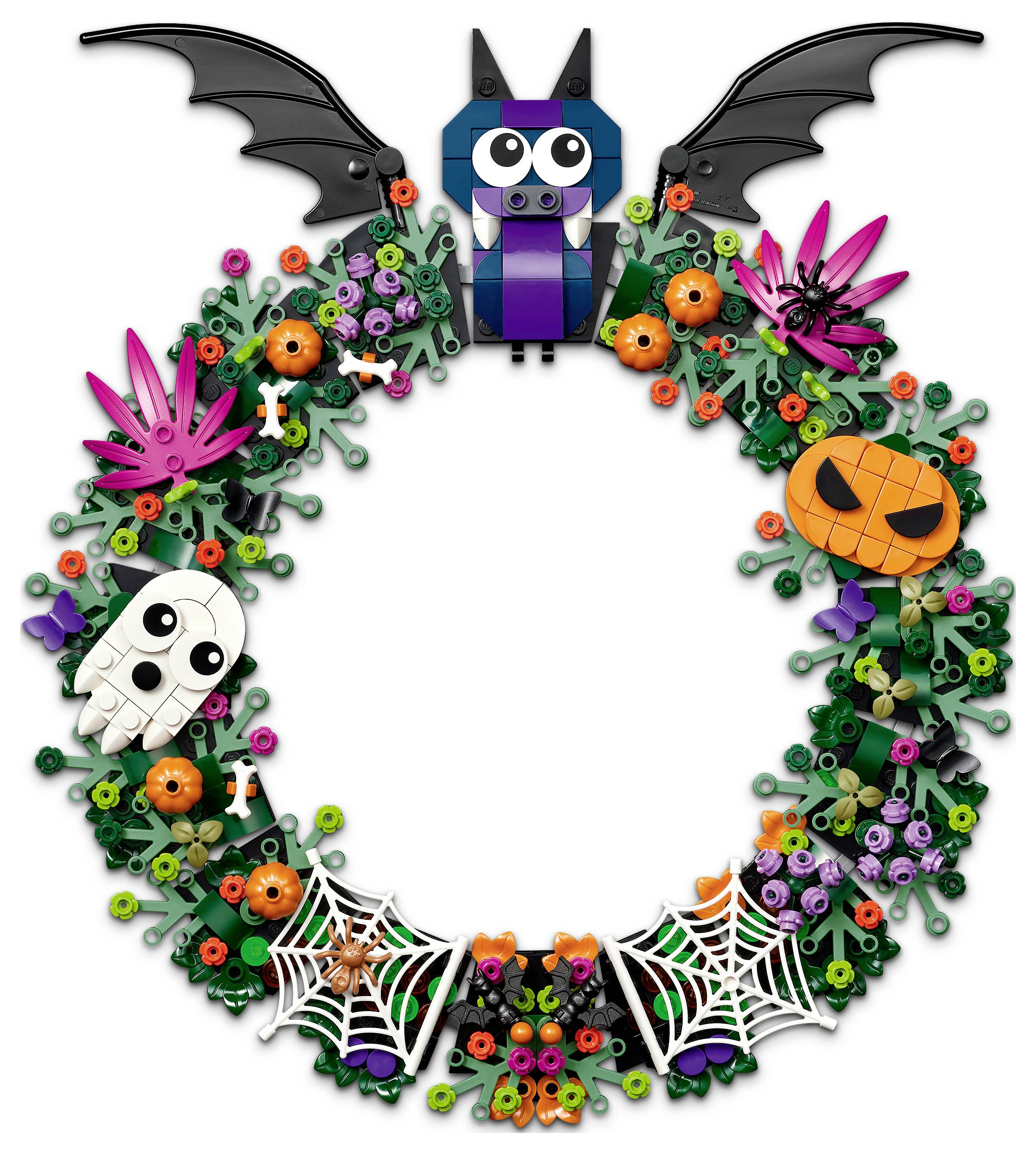Halloweenský věnec vyrobený z barevných květin a pavouků s netopýrem, dýní, lebkou a pavučinami kolem prázdného středu.