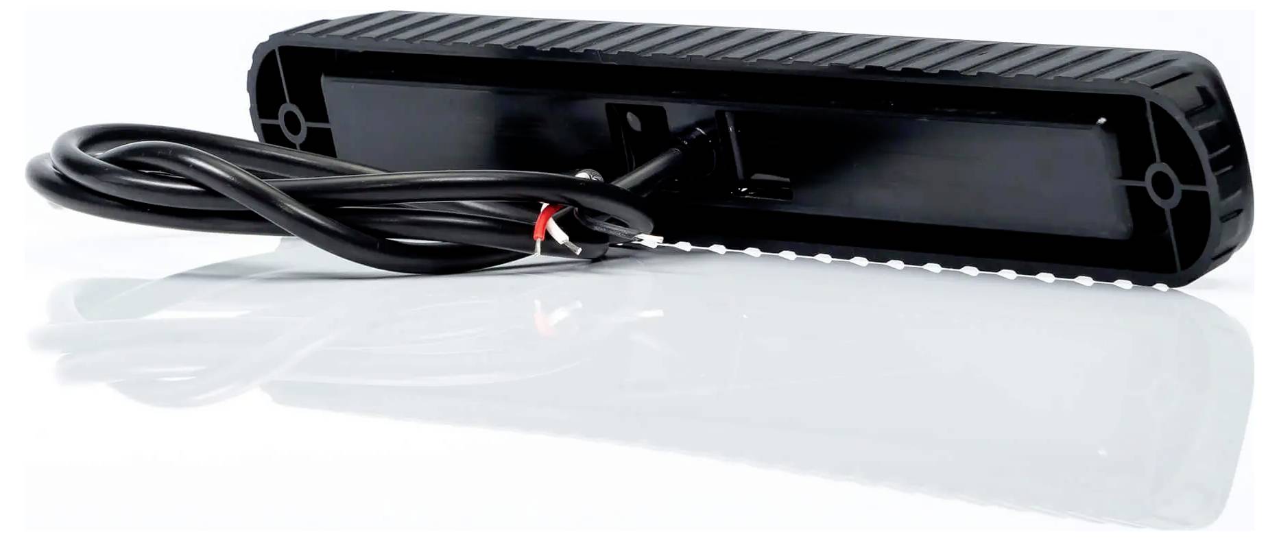 Černé obdélníkové elektronické zařízení se spirálovým napájecím kabelem, zobrazené na bílém pozadí s reflexní plochou.