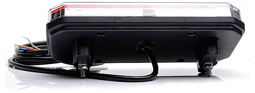 Zadní pohled na černé obdélníkové elektronické zařízení s připojenými kabely a dvěma montážními příspěvky, zobrazené na bílém pozadí.