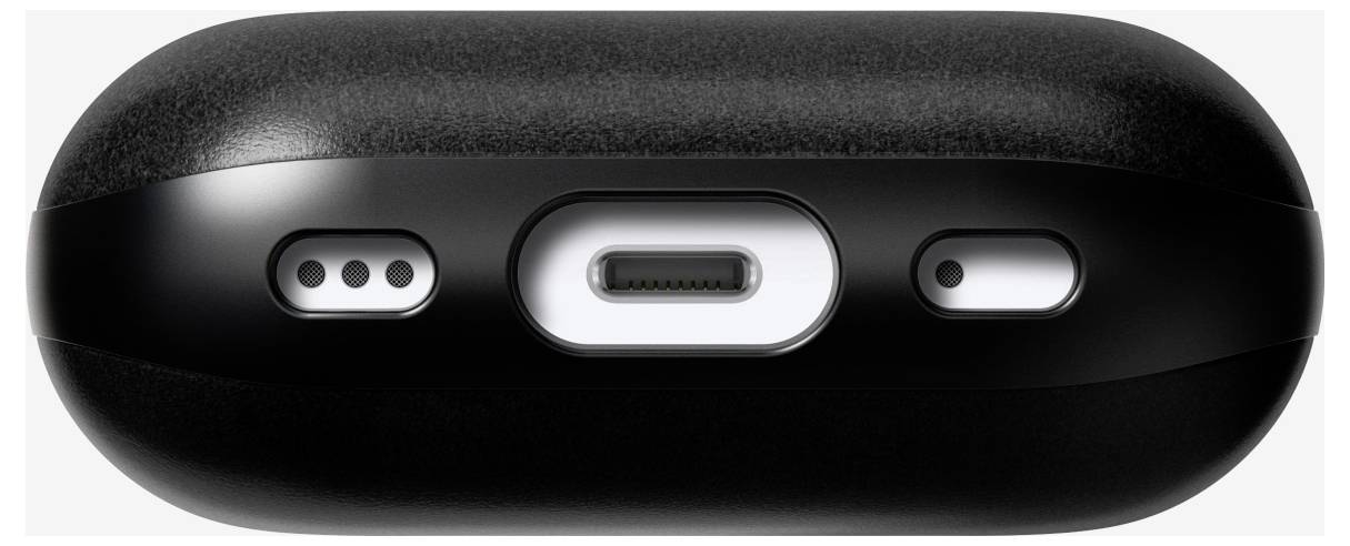 Detailní záběr na černé bezdrátové sluchátko s nabíjecím pouzdrem zobrazující spodní část s otvory reproduktoru, portem USB-C pro nabíjení a stavovým indikátorem.