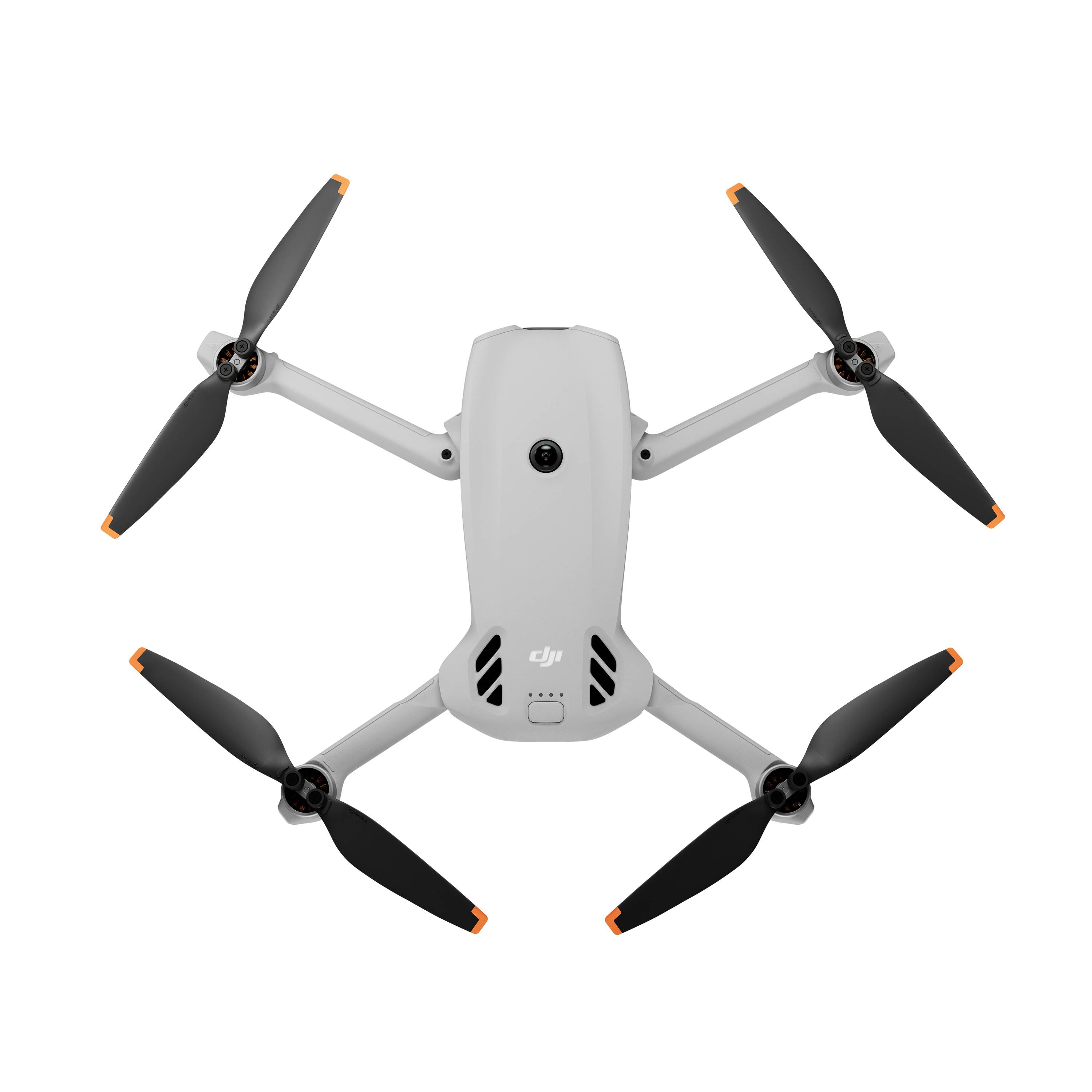 Pohled shora na bílý kvadrokoptéru DJI s čtyřmi vrtulemi na prostém pozadí.