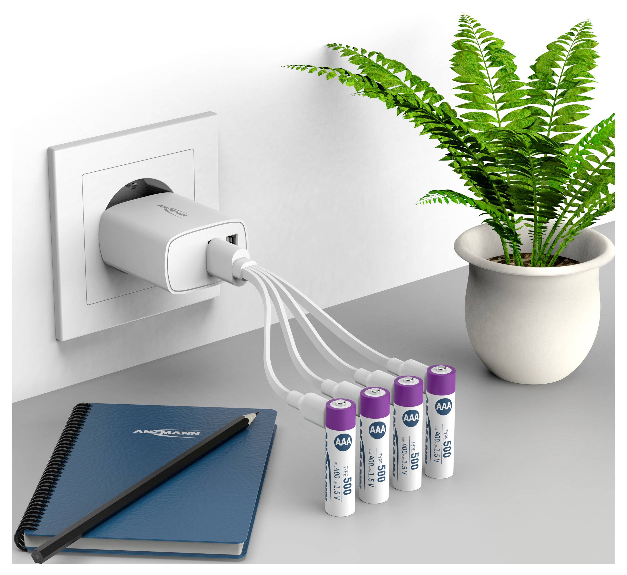 USB nabíječka vedle květináče napájí čtyři baterie AA spojené kabely na stole s poznámkovým blokem a tužkou.