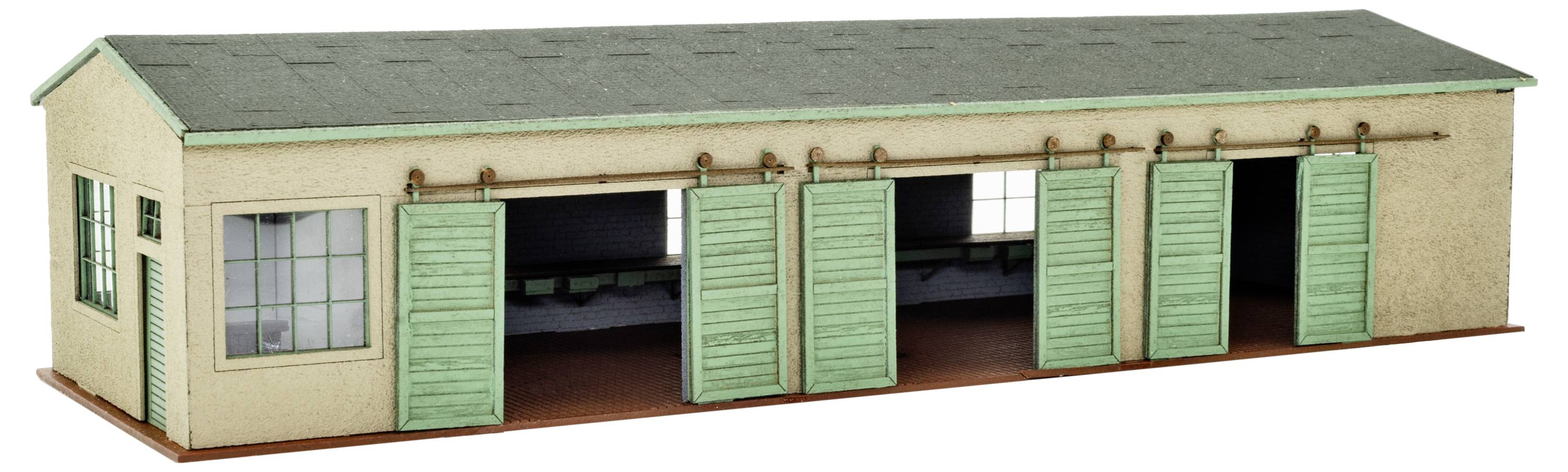 Miniaturní model béžové průmyslové budovy se zelenou střechou a otevřenými mintovými posuvnými dveřmi, které odhalují interiér.