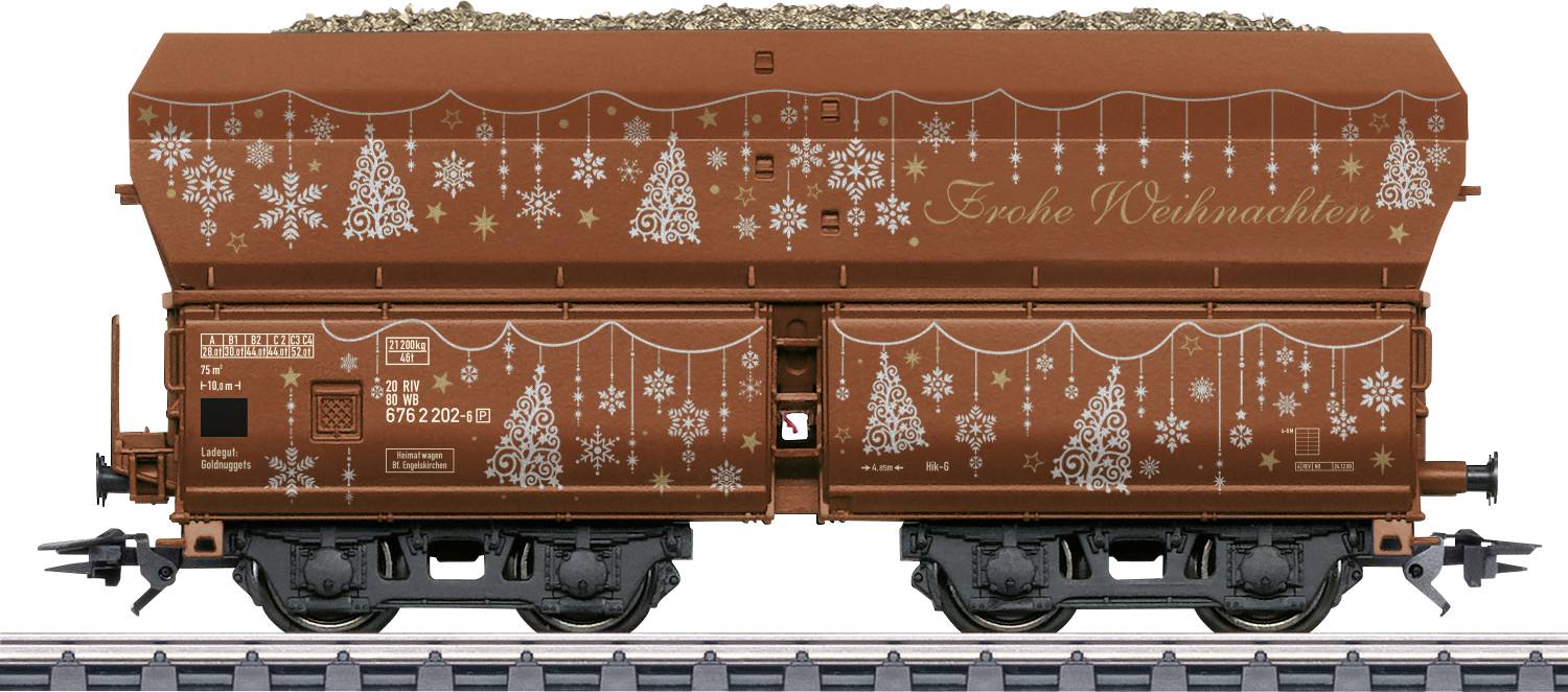 Boční pohled na hnědý nákladní vozidlo typu hopperového vozu zdobený bílými vánočními stromky a vločkami, na boku je napsáno "Frohe Weihnachten".