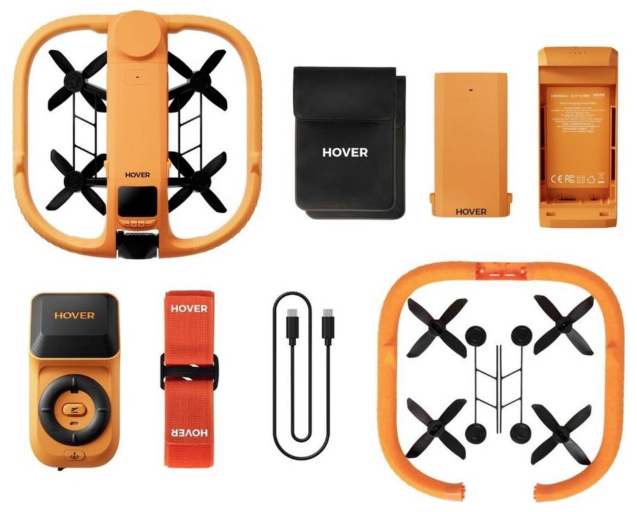 Sada Orange HOVER dronu zobrazená s dronem, baterií, nabíječkou, dálkovým ovladačem, popruhem, USB kabelem a ochranným rámem/příslušenstvím roloženými na bílém pozadí.