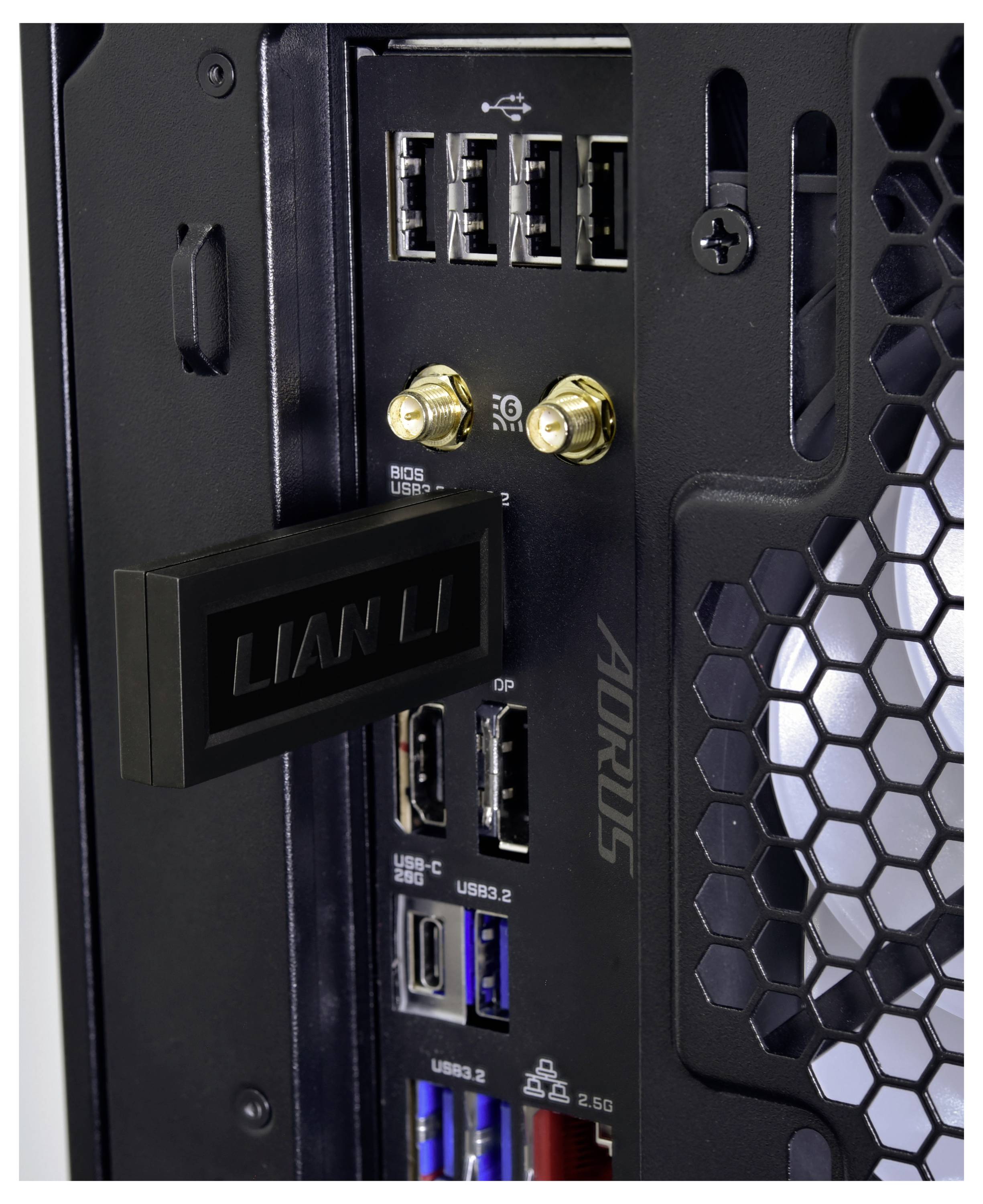 Detailní pohled na zadní I/O panel desktopové PC základní desky s USB porty, konektory Wi-Fi antény, tlačítky BIOS/UEFI a značkou AORUS blízko otvorů větrání pouzdra ve tvaru včelího plástve.