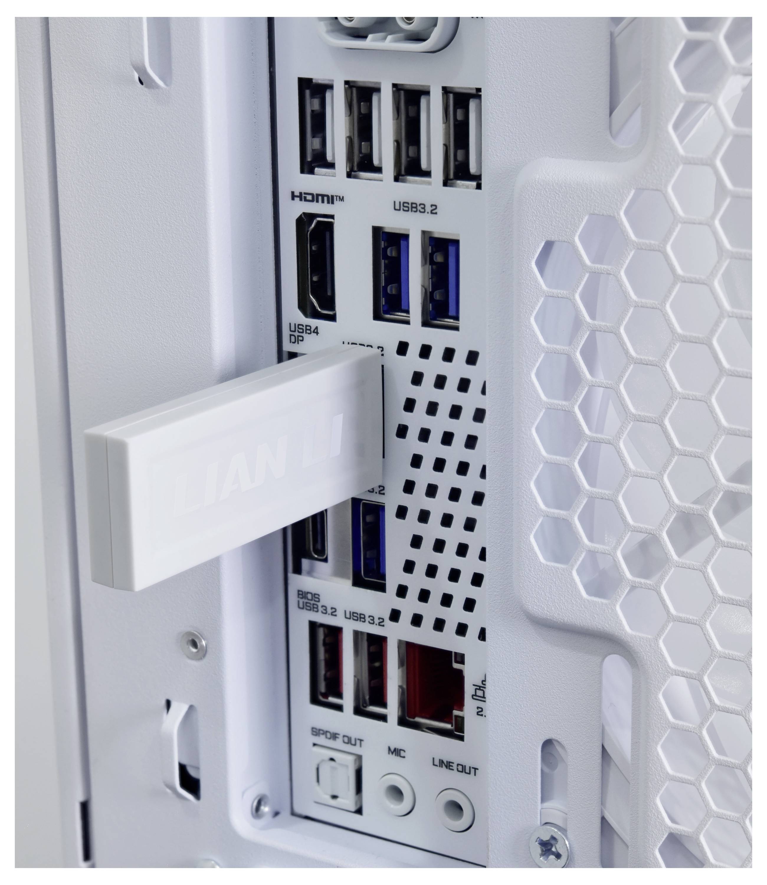 Detailní záběr na zadní panel I/O bílé PC skříně s porty HDMI, USB 3.2/USB 4, audio a síťovými porty, částečně zakrytými bílou závorkou.