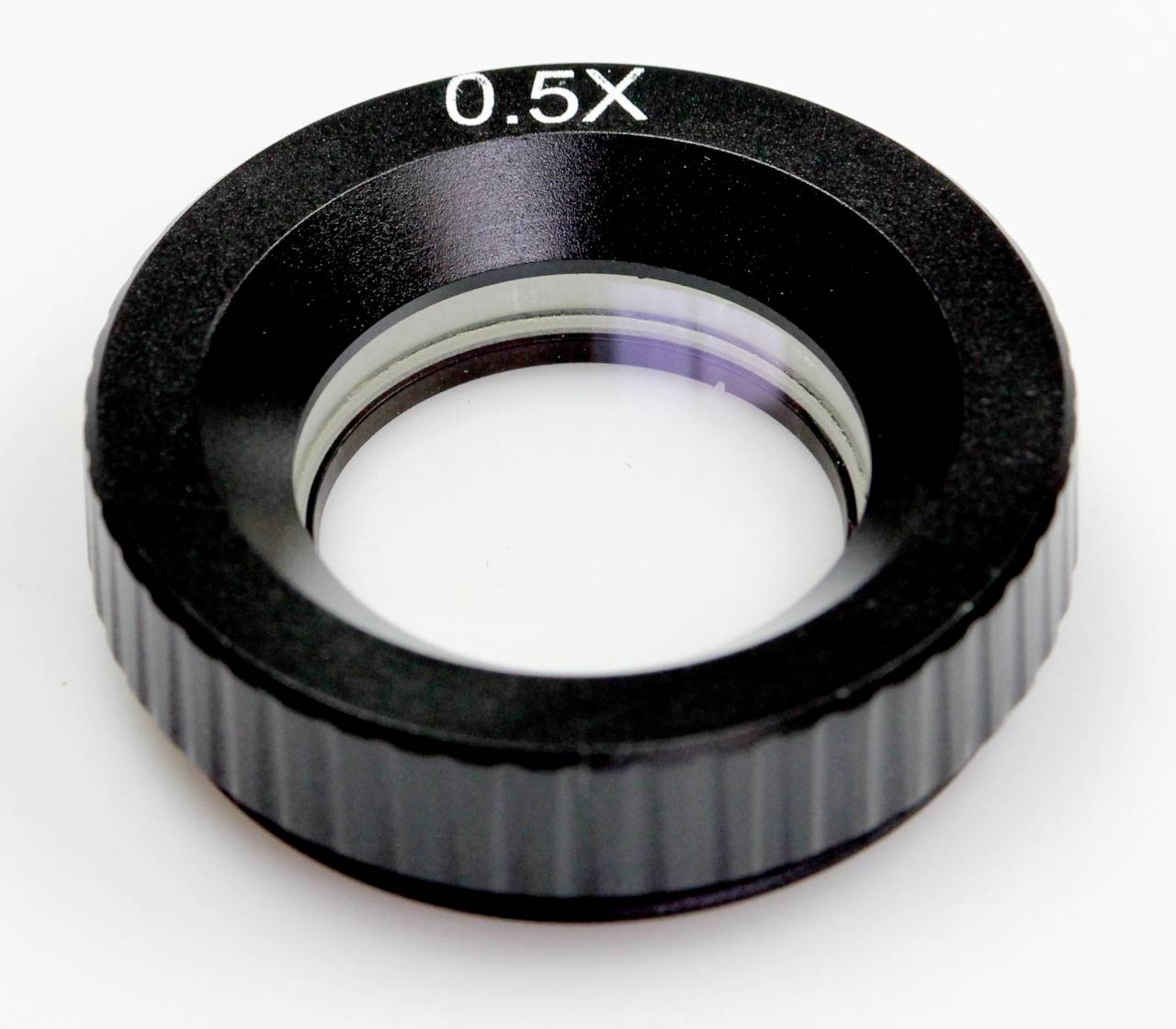 Adaptér objektivu fotoaparátu Black 0.5X zobrazený v detailním zobrazení na bílém pozadí.