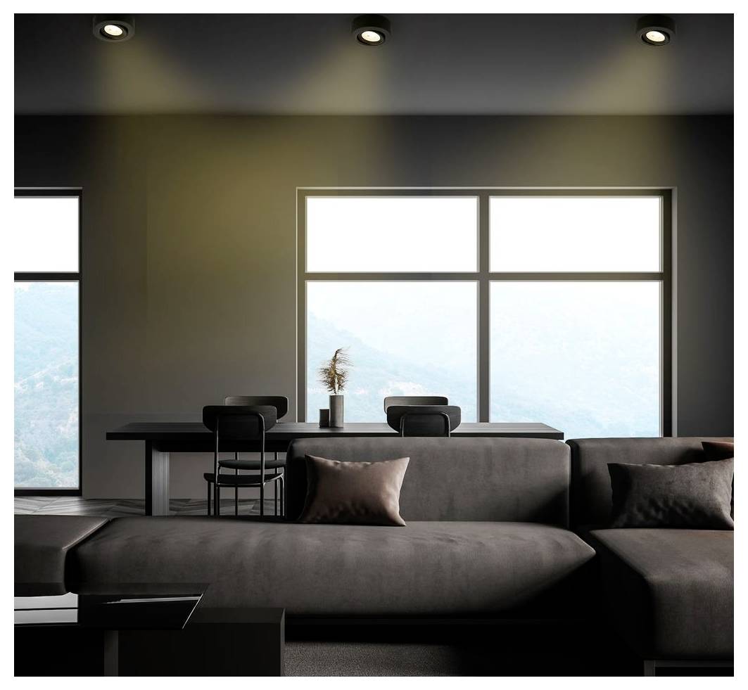 Moderní obývací pokoj s tmavou rohovou sedačkou, jídelním stolem a velkými okny s mlhavým výhledem ven.