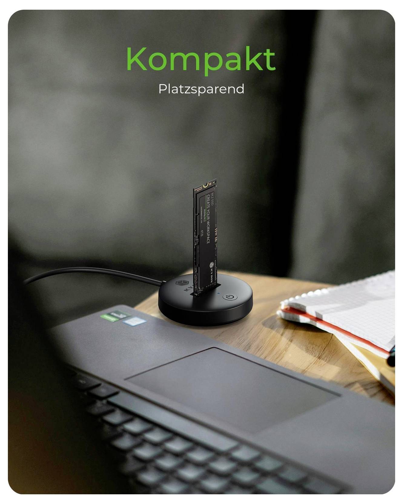 Kompaktní, prostorově úsporný laptop dock se vertikální SSD na kulaté podstavě vedle notebooku; text zní „Kompakt" a „Platzsparen".
