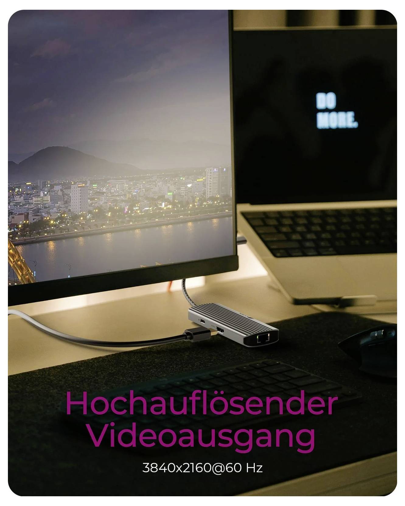 Dokovací stanice laptopů připojená k externímu monitoru zobrazující městský výhled s německým textem „Hochauflösender Videoausgang" a „3840x2160@60 Hz", což znamená 4K video výstup.