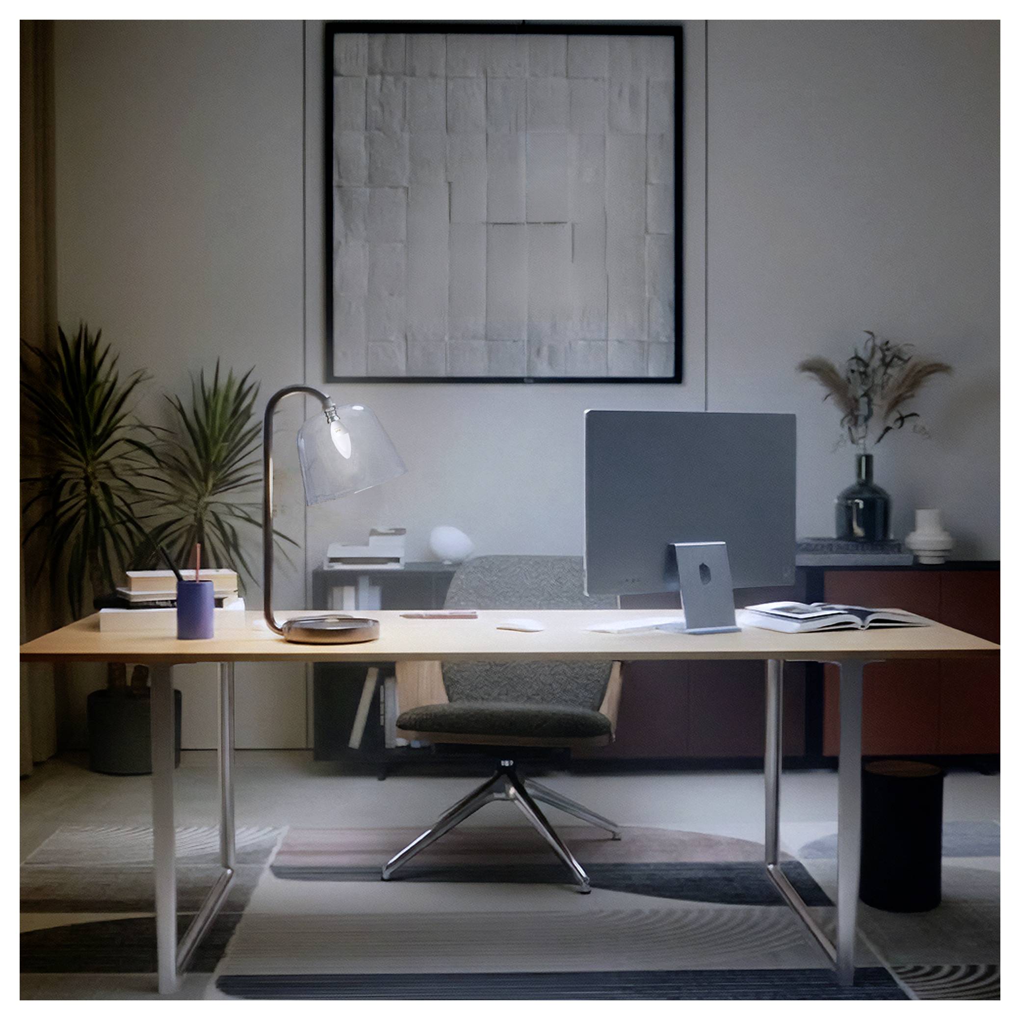 Moderní minimalistická kancelář s psacím stolem, monitor počítače, židlí, lampou, knihami, rostlinami a obrámy na stěně.