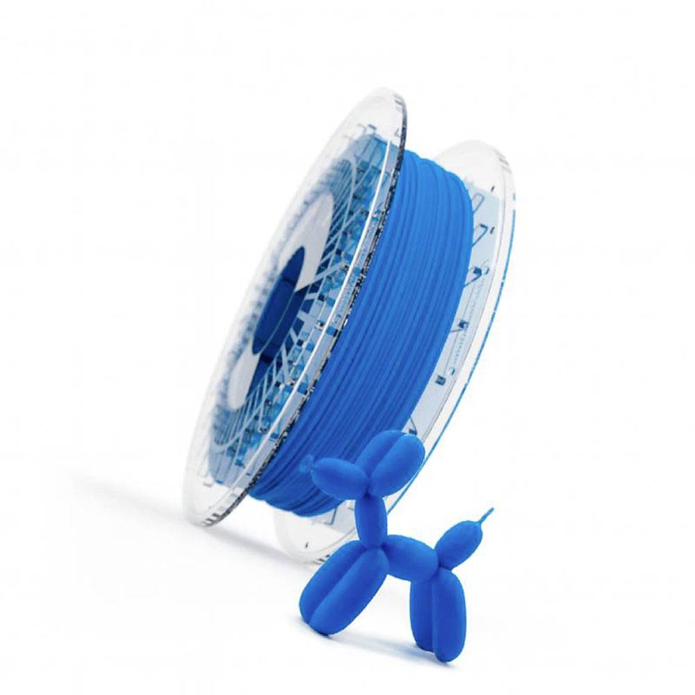 Modrá 3D tištěná figurka psa opírající se o cívku modrého filamentu na bílém pozadí.