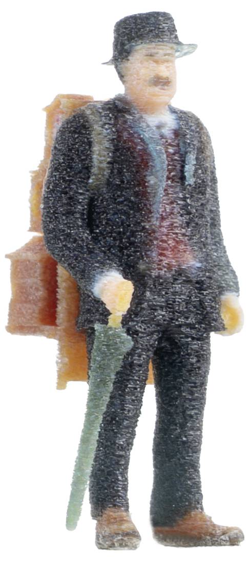 Miniaturní figurka muže v obleku a klobouku, stojícího se zeleným deštníkem a hnědým kufrem na zádech.