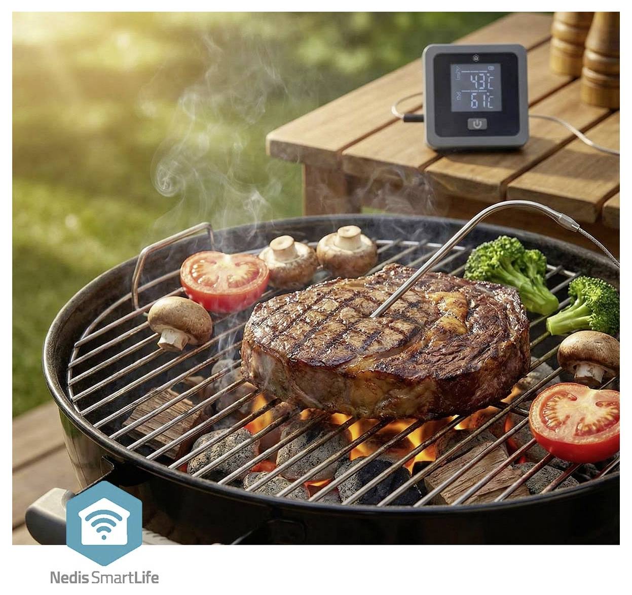 Steak, zelenina a houby grilující se na uhlíkovém grilu s digitálním teploměrem na dřevěném stole.