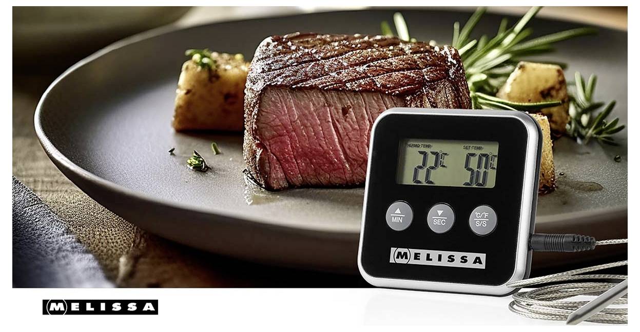 Digitální teploměr na maso zobrazující 22°C a 50°C vedle vařeného hovězího steaku na talíři s logem "MELISSA".