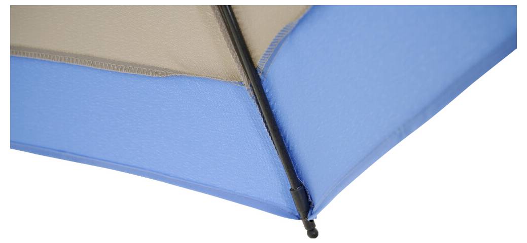 Detailní snímek modro-béžového plážového slunečníku s černou podpůrnou tyčí na bílém pozadí.