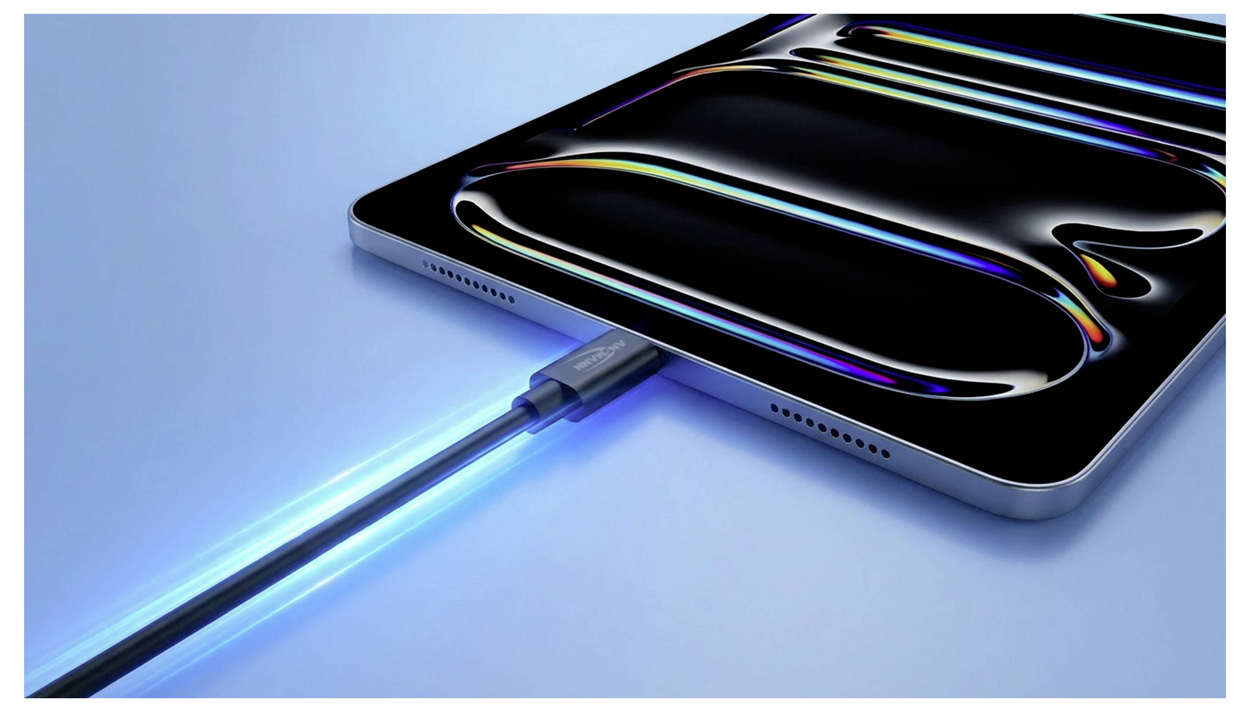 Tablet se nabíjí svítícím modrým kabelem připojeným k portu USB-C na modrém pozadí.