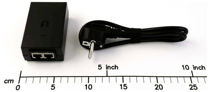 Černý rozdělovač napájení přes Ethernet se dvěma porty Ethernet a napájecím kabelem zobrazený na pravítku pro porovnání velikosti; délka kabelu označena od 5 palců do 10 palců.