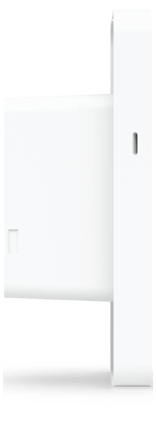 Minimalistické bílé obdélníkové zařízení nebo panel připevnený na stěnu s úzkým vertikálním štěrbinou a malým vřazeným otvorem, znázorněno na prostém bílém pozadí.