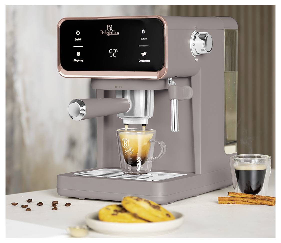 Moderní espresso stroj vaří kávu do sklenice, v okolí jsou zrnka kávy, sušenky, skořicové tyčinky a malý šálek espresa.