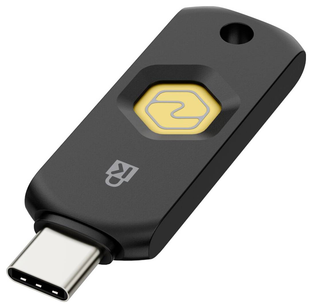 Černý bezpečnostní klíč USB-C se žlutým šestiúhelníkovým dotykovým tlačítkem a otvorem na klíč, zobrazen na bílém pozadí.