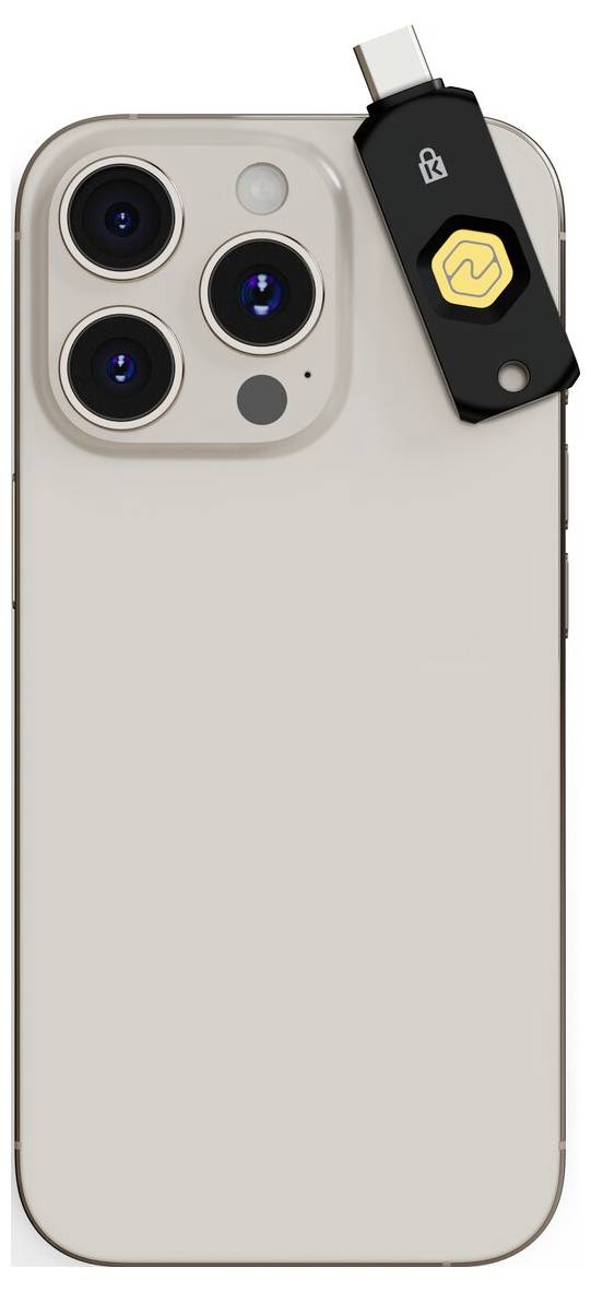 Béžový zadní kryt iPhonu s trojitým shlukkem fotoaparátů a černým bezpečnostním klíčem USB-C připevněným na pravé straně nahoře.