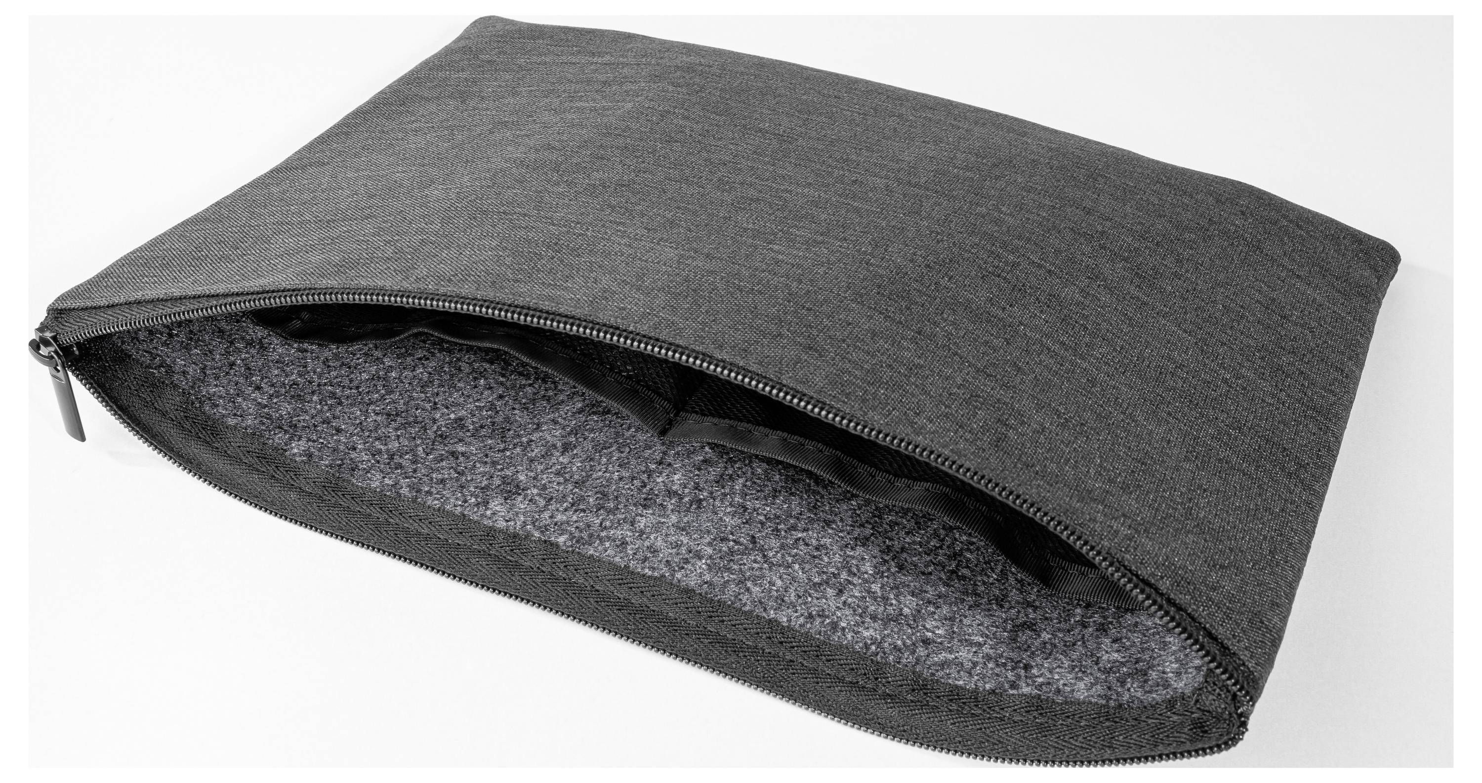 Šedý obal na laptop se zipem nebo ochranné pouzdro, částečně otevřené, aby bylo vidět měkké interiér vyložený plstí.