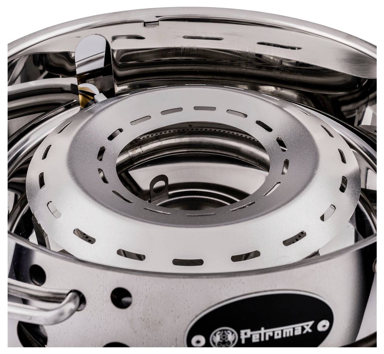 Detailní záběr přenosného plynového vařiče Petromax s kulatými ventilačními štěrbinami vyrobeného z nerezové oceli a viditelným logem Petromax.