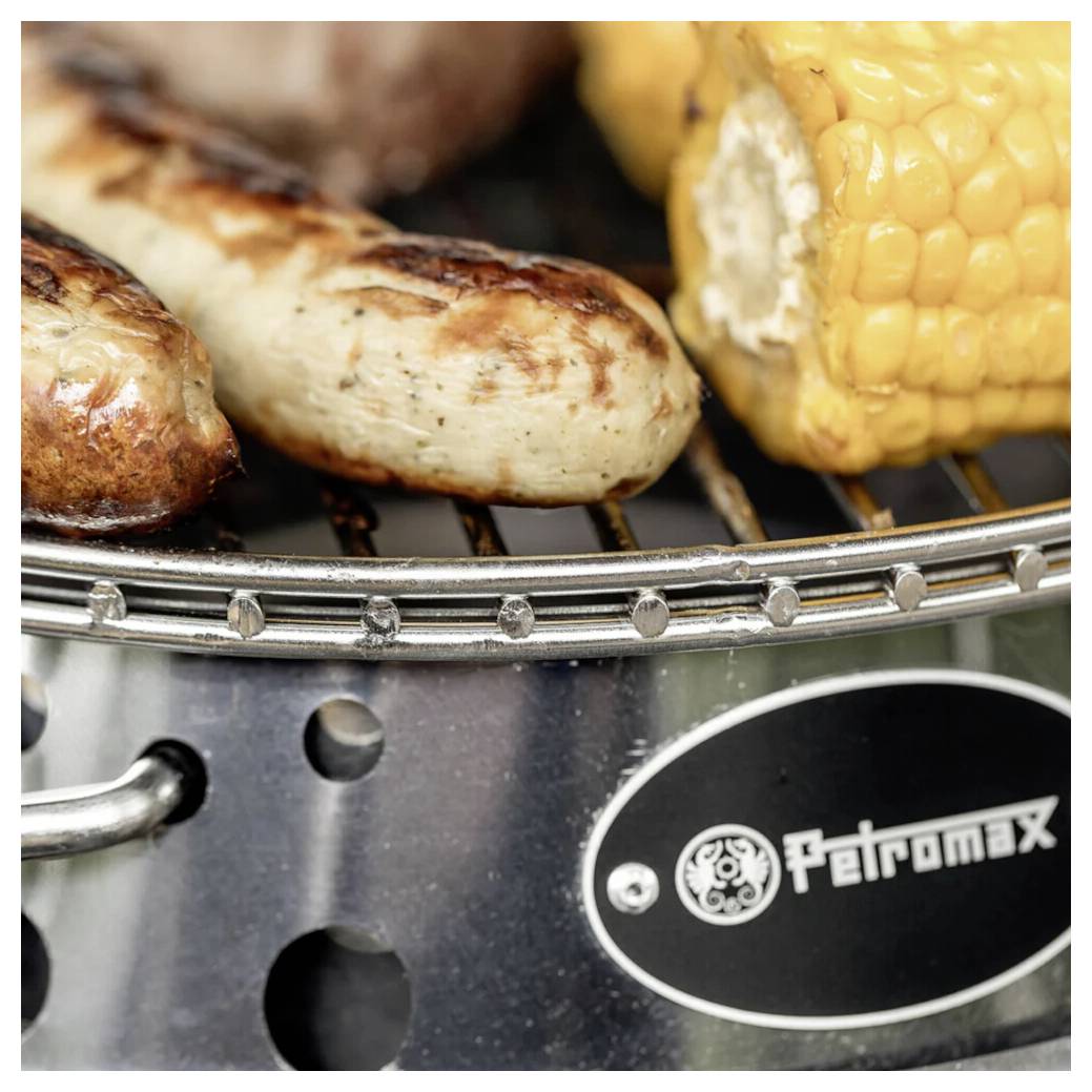 Párky a kukuřice grilované na grilu Petromax na dřevěné uhlí.