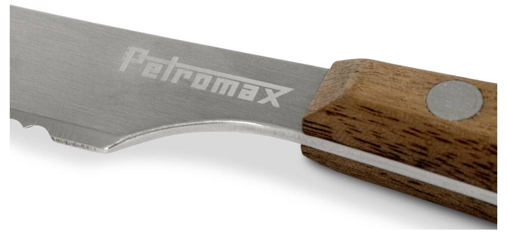 Detailní záběr na skládací pilový list Petromax se stříbrným kovovým listem a dřevěnou rukojetí na bílém pozadí.