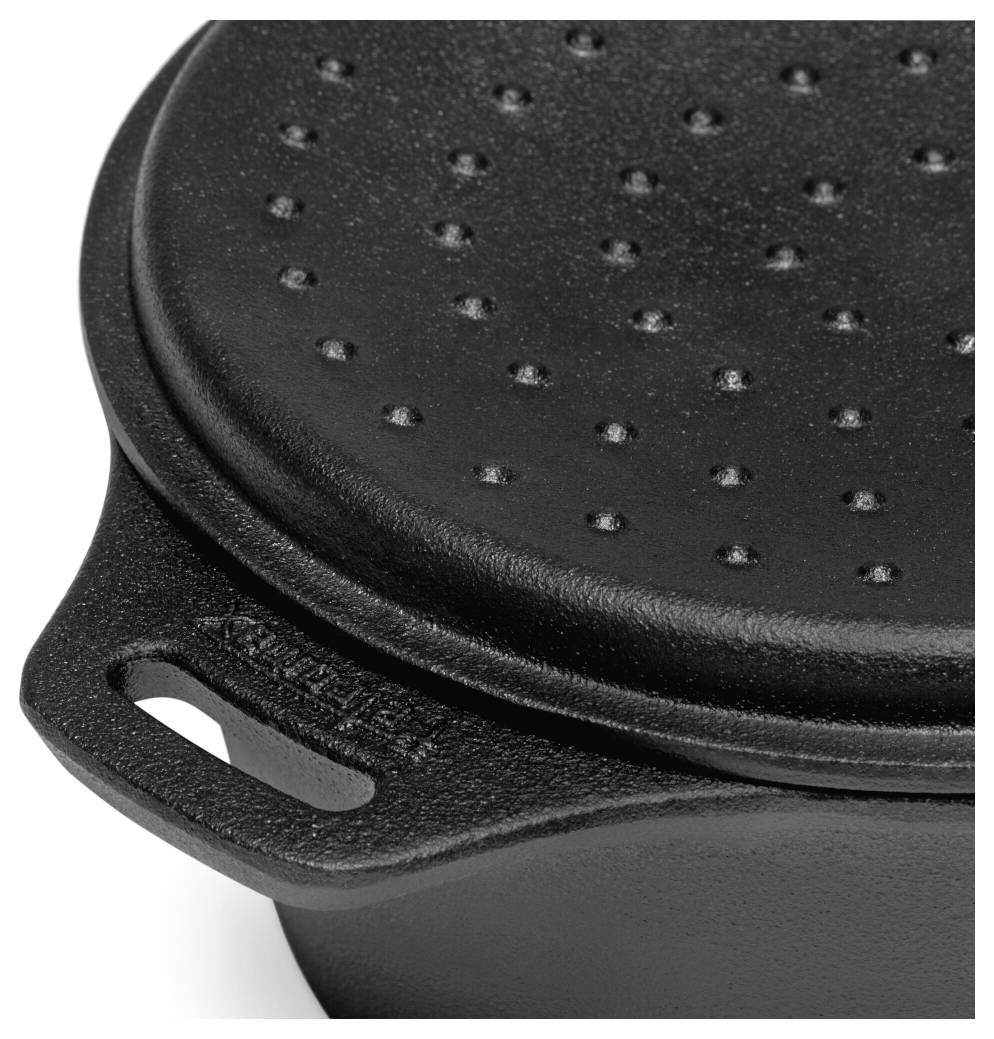 Zavřete fotografie černého litinového hrnce s děrovaným víkem a postranní rukojetí na bílém pozadí.