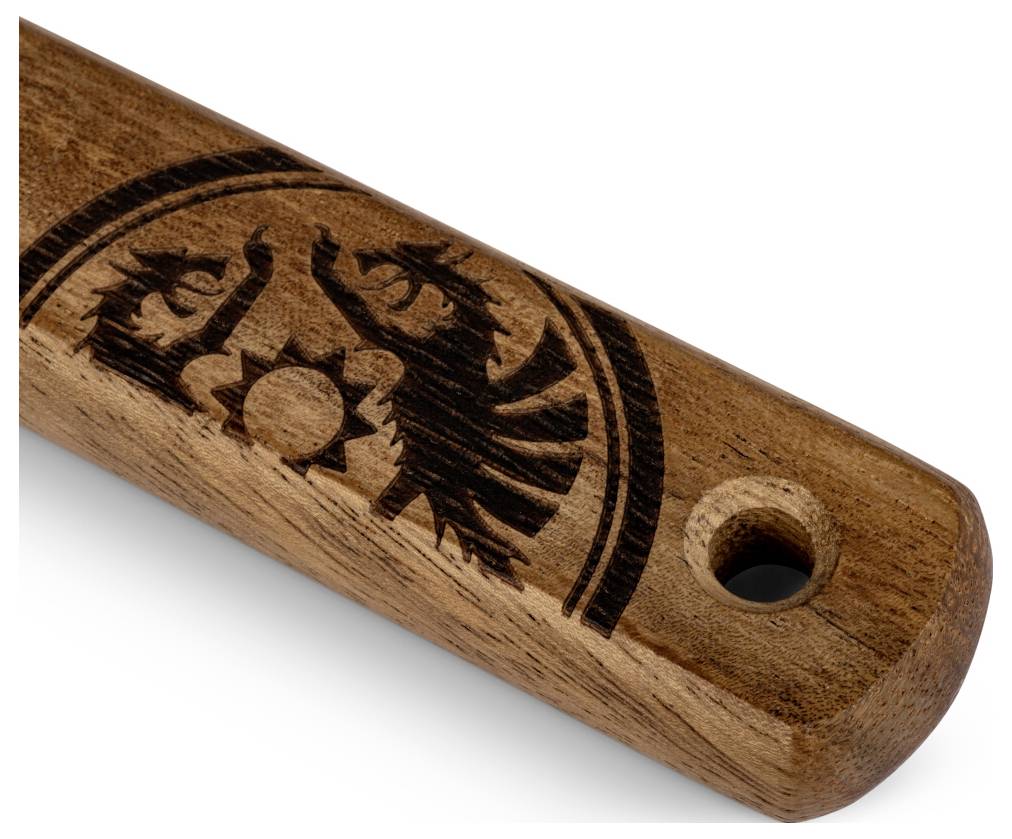 Detailní záběr na dřevěný hold se vypáleným znakem orla a slunce a otvorem na zavěšení na konci.