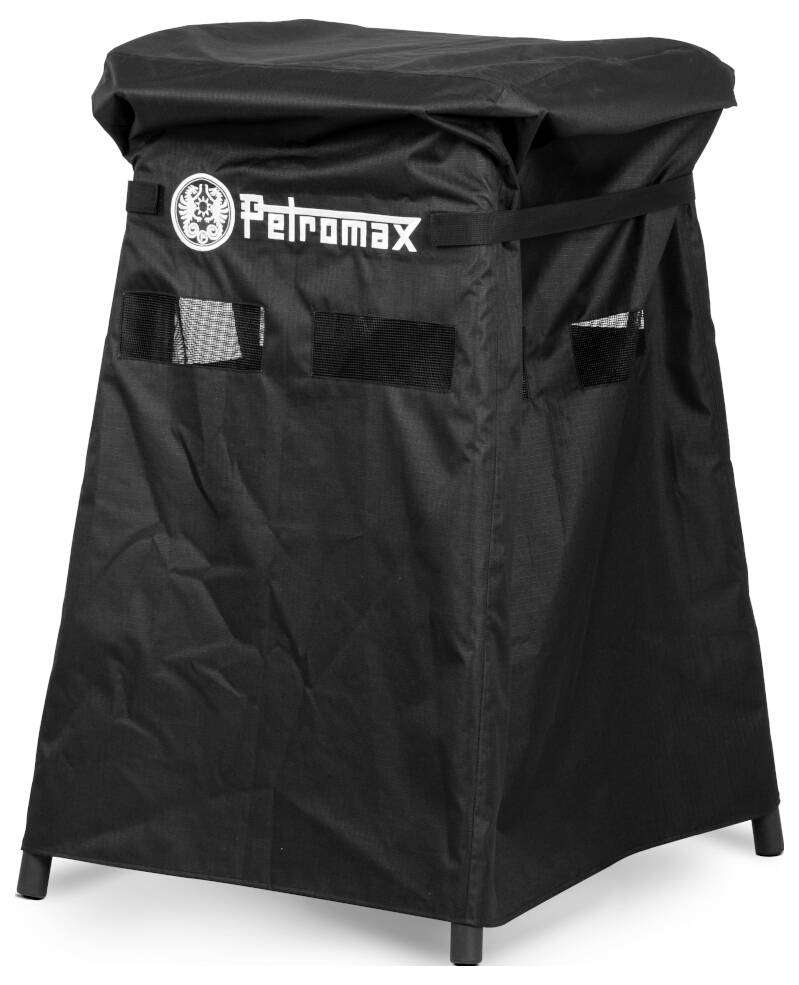 Černý ochranný kryt Petromax nasazený na čtvercový venkovní sporák nebo gril se stranovými otvory a viditelným čtyřnožým stojanem.