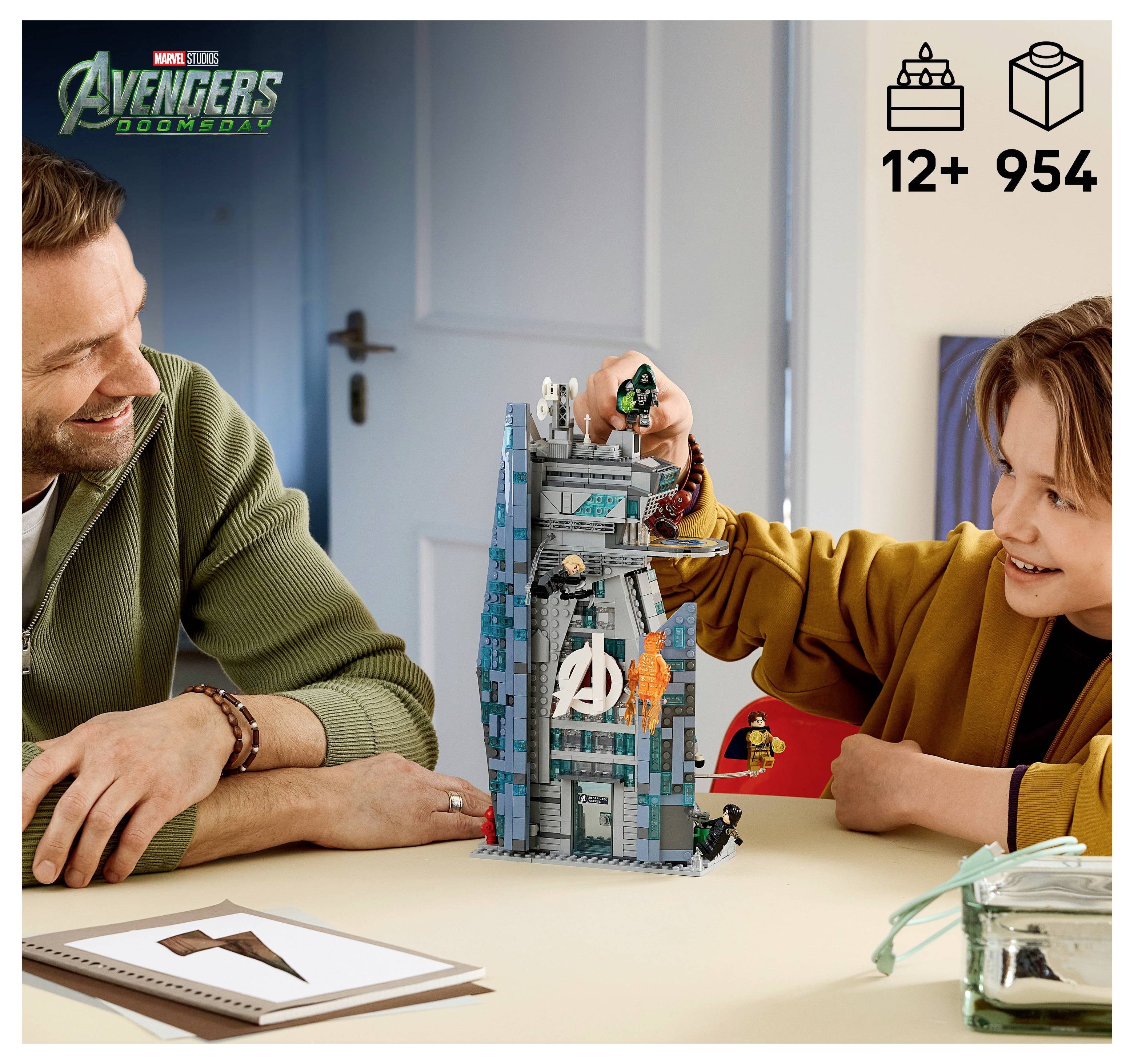 Otec a dítě stavějí sadu LEGO věž s motivem Avengers na stole; věk 12+ a 954 dílků jsou zobrazeny.
