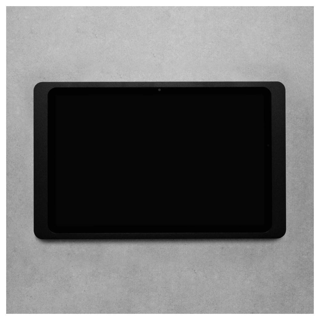 Černý tablet s prázdnou obrazovkou na světle šedém povrchu.