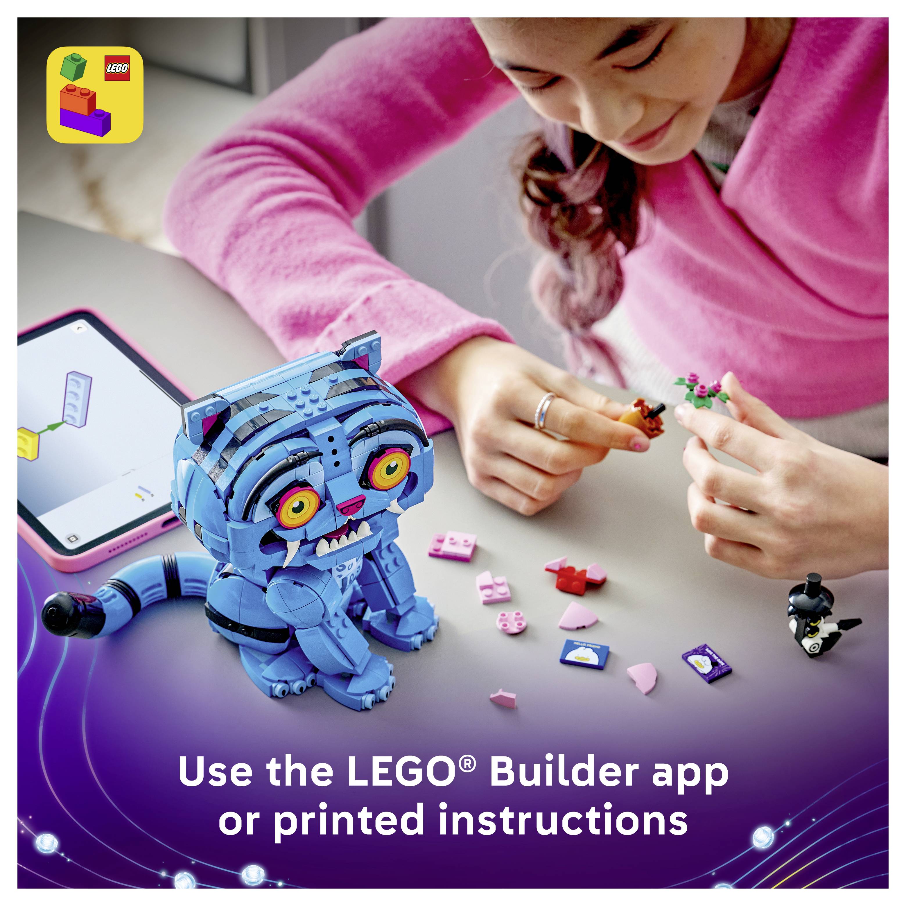 Dívka skládá modrý model postavy LEGO z malých součástek na stole, vedle tabletu; text říká "Použijte aplikaci LEGO Builder nebo tištěné pokyny".